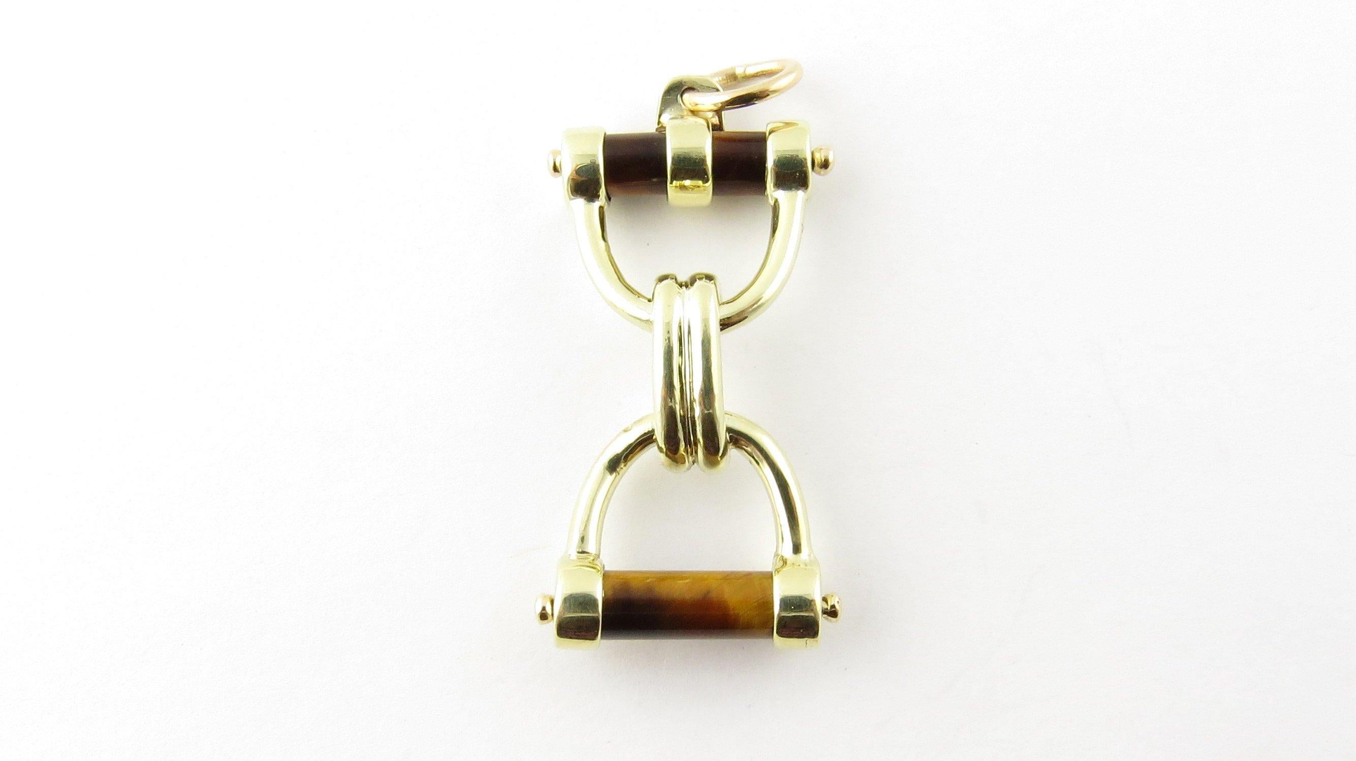 Vintage 14 Karat Yellow Gold and Tiger's Eye Horse Bit Pendant- 
Perfect gift for the horse lover. 
This stunning pendant features a lovely horse bit decorated with two tiger's eye bars beautifully detailed in 14K yellow gold. 
Size: 33 mm x 18 mm