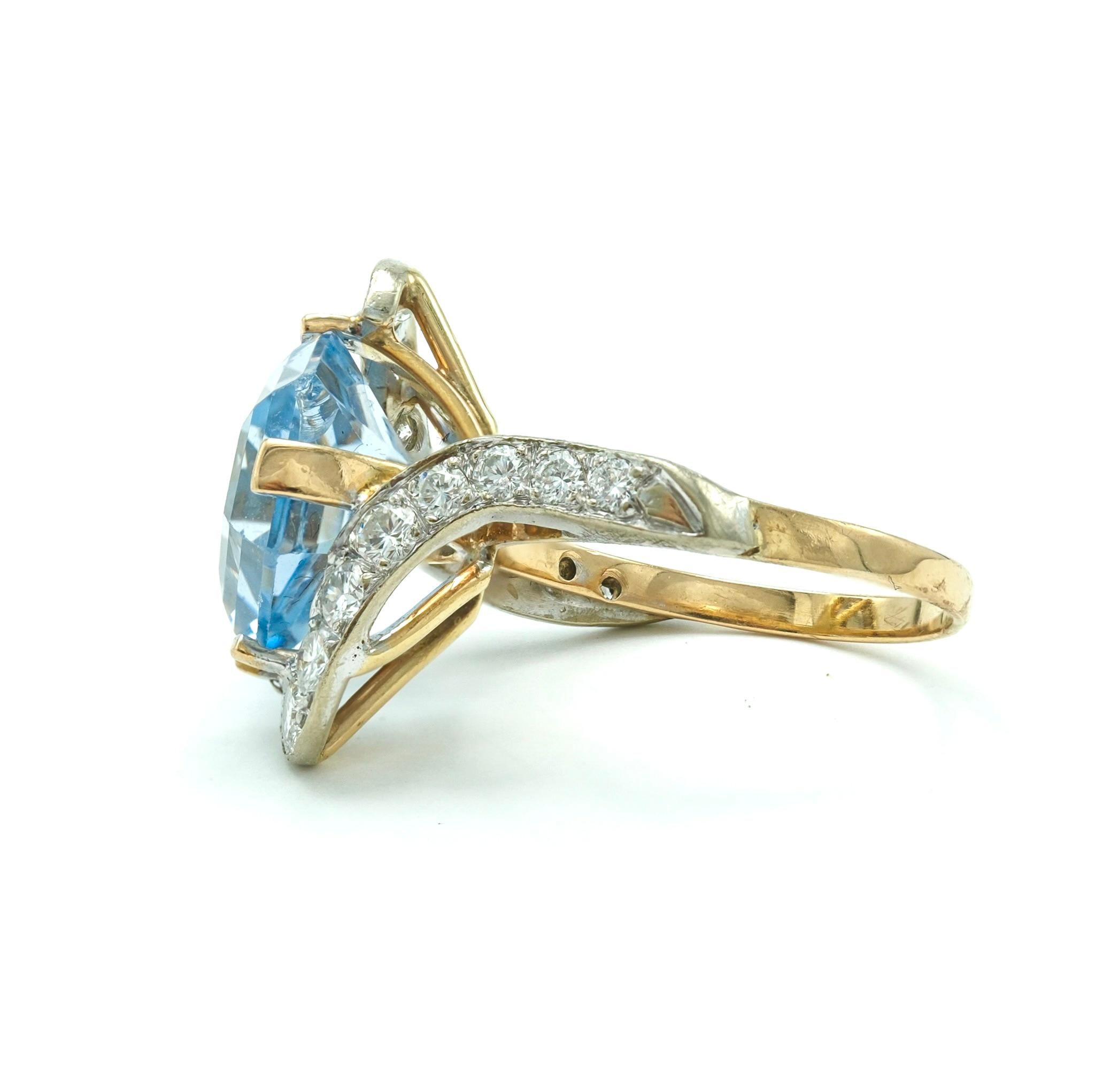 This ring, forged in 14 karat yellow gold, centers around a clear, 6.5 carat hexagonal topaz. On either side, a total of 16 diamonds, weighing in at 0.8 carats, set bright blue stone. The design brings together the bold presence of a cocktail ring