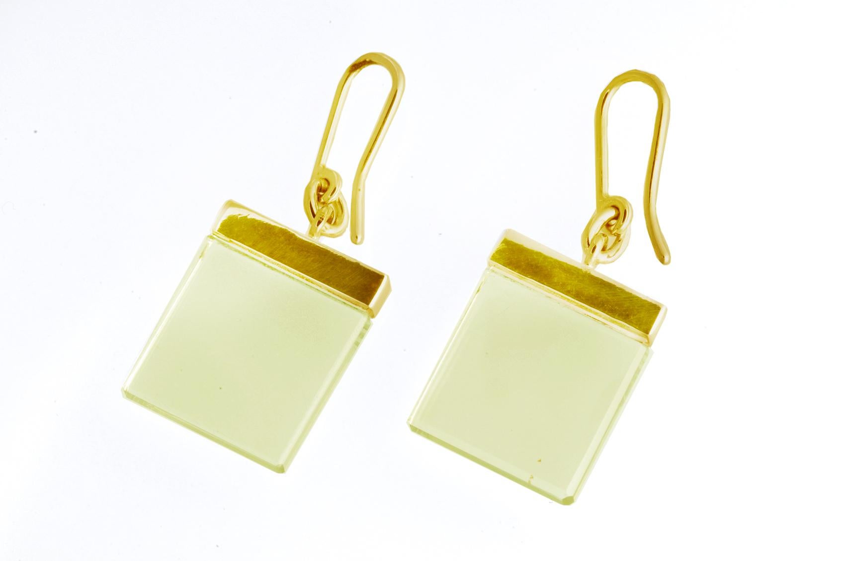 These elegant earrings are part of the Ink collection, designed by Berlin-based oil painter, Polya Medvedeva. Made of 14 karat yellow gold, the earrings feature 15x15x3 mm transparent lemon quartzes that allow light to pass through. The minimalistic