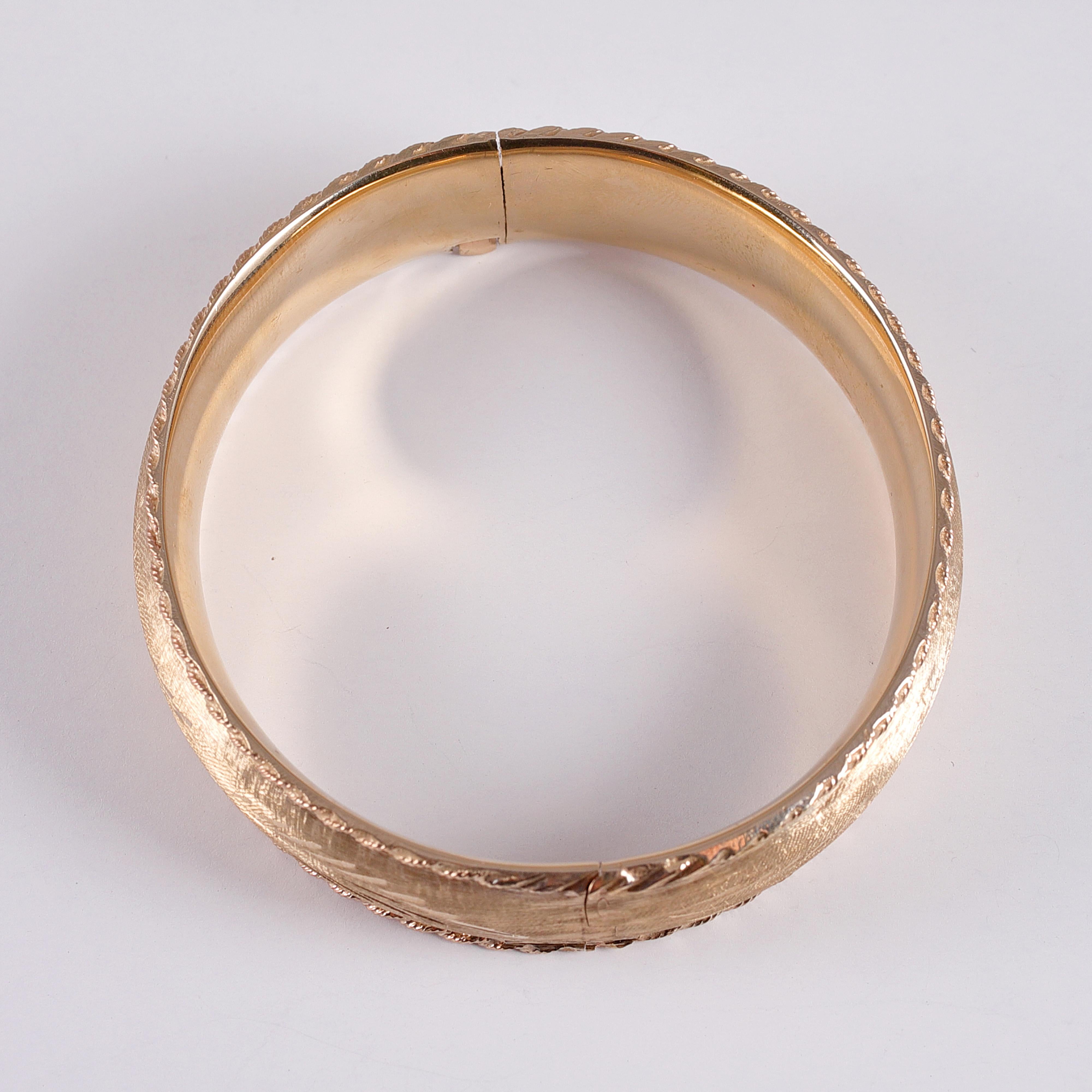 14 karat yellow gold brushed bangle with rope trim.  This hinged bangle looks great alone or stacked.