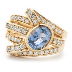 14 Karat Yellow Gold Bezel Set Cornflower Blue Sapphire and Diamond Bypass Ring