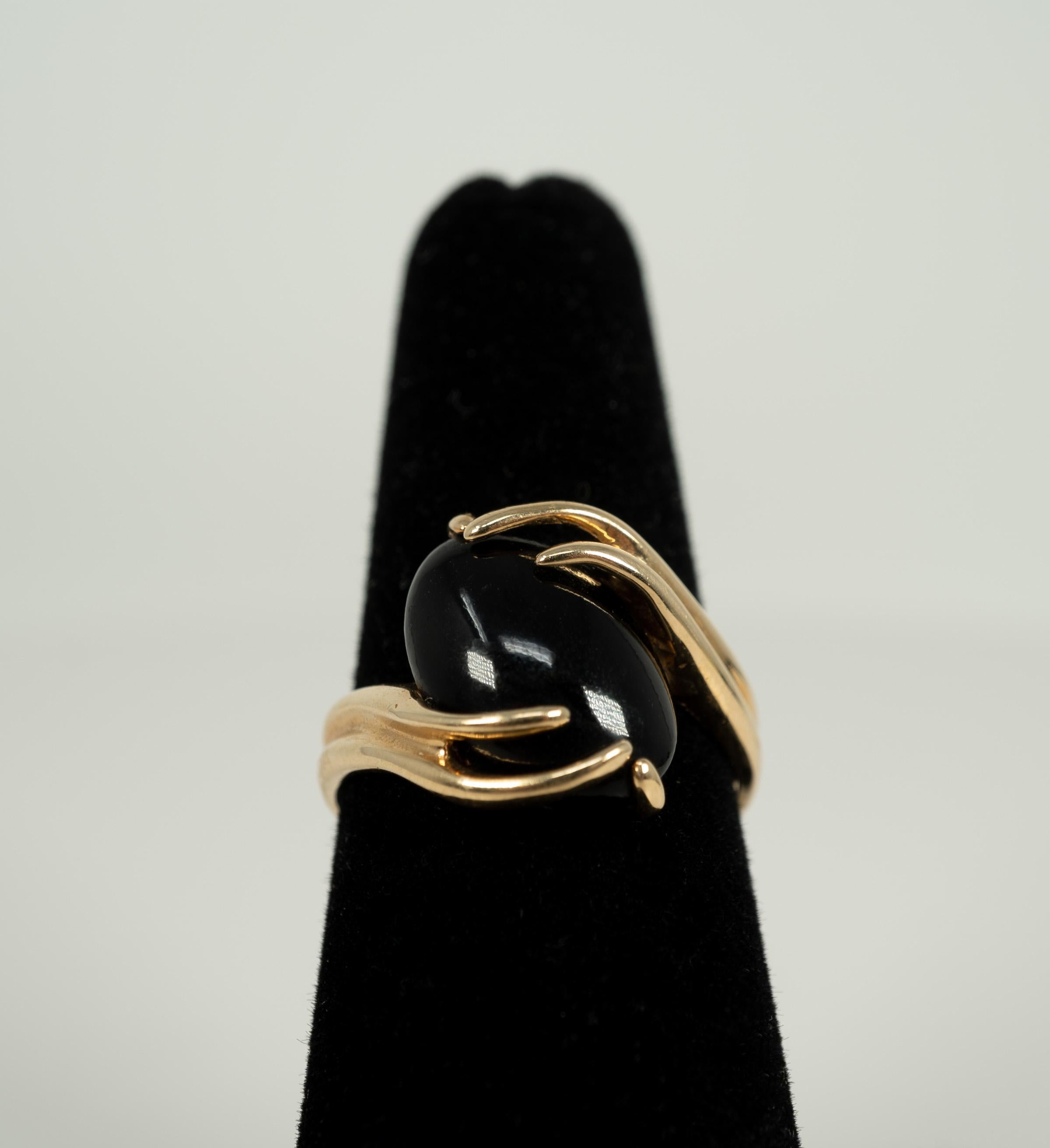The glow of this oval-shaped, cabochon-cut black coral is lovely with the rich yellow gold mounting!