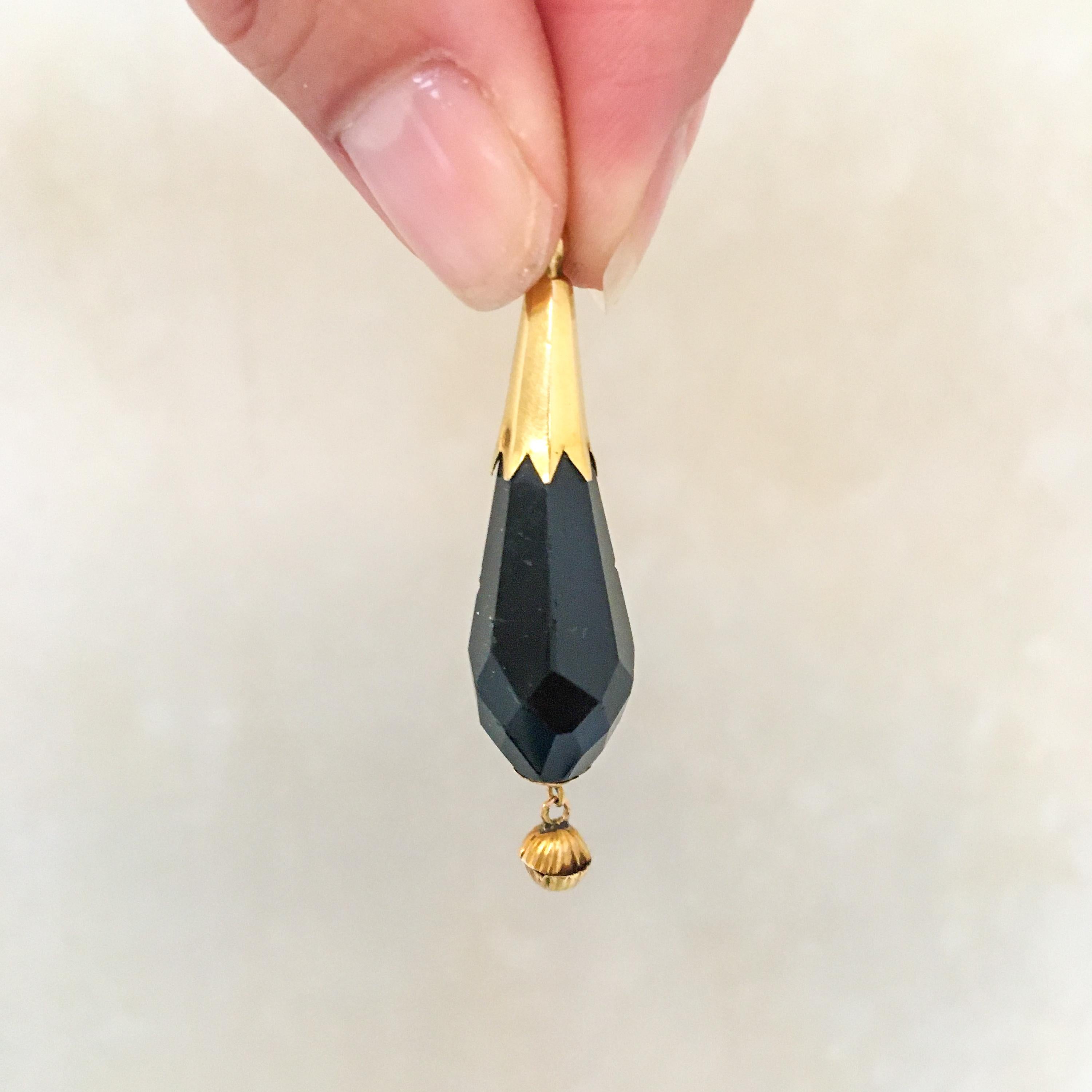 These antique 1850's faceted black jet pendants are created in 14 karat yellow gold. The black stone, also known as black yet, is beautifully faceted into this briolette shaped pendants. The gold on top has nicely jagged edges, while the bottom is