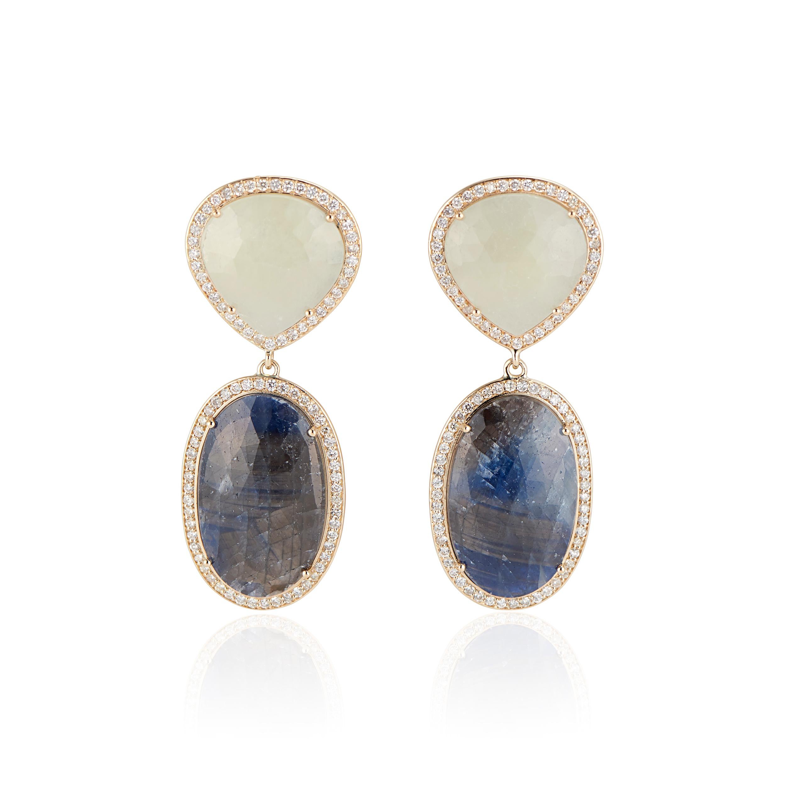 Bellezza e lusso unici nel loro genere: orecchini in oro giallo 14k con zaffiro blu a forma di fetta ovale e zaffiro crema a fetta con diamante a raggiera.

Ogni orecchino presenta un'affascinante fetta ovale di zaffiro blu e una fetta di zaffiro