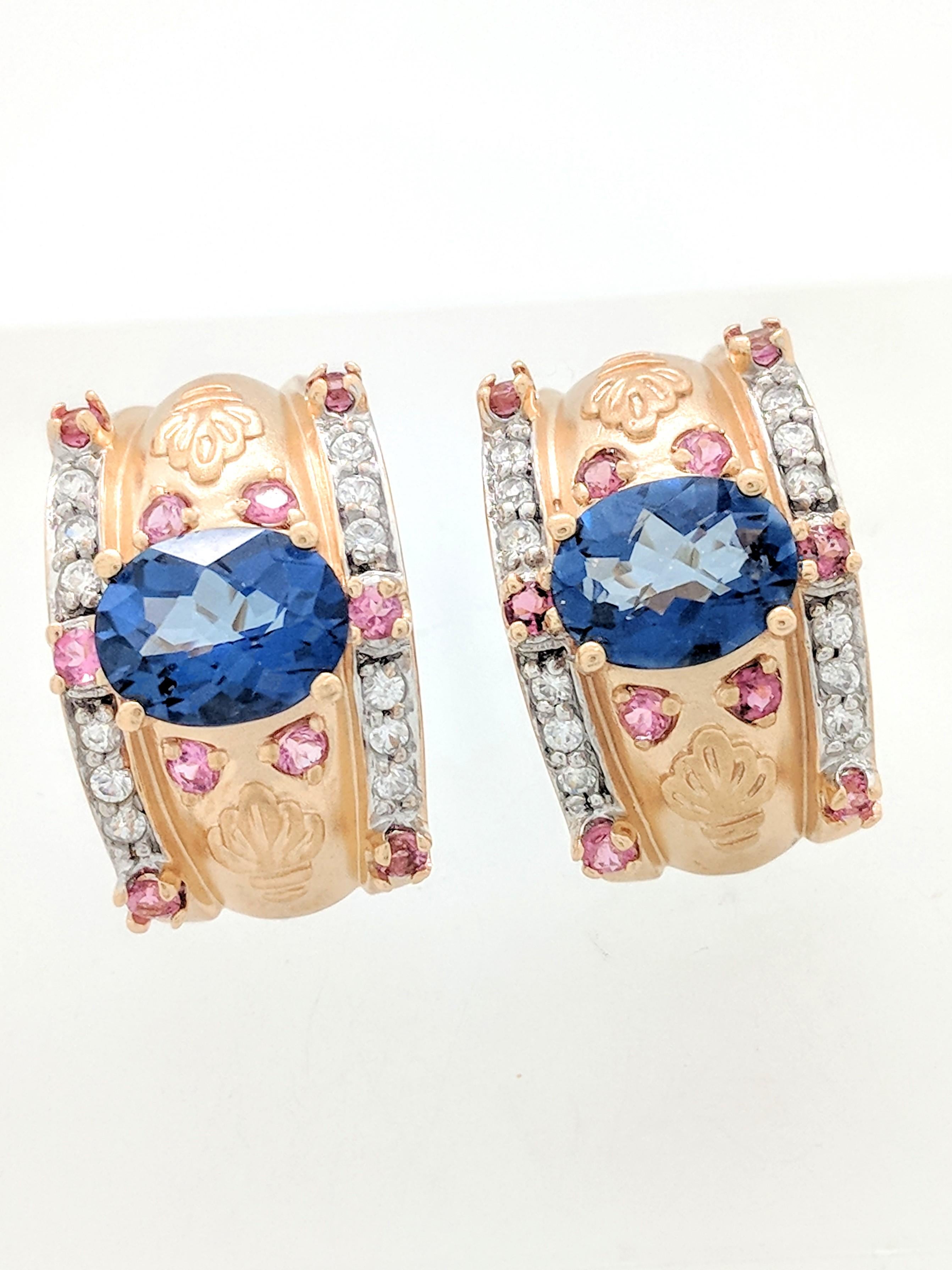 You are viewing a pair of blue sapphire, pink sapphire & diamond earrings. These earrings are crafted from 14k yellow gold and weigh 10.4 grams. Each earring features (1) 9x7mm oval prism cut blue sapphire, (10) 2mm round pink sapphires and (12)
