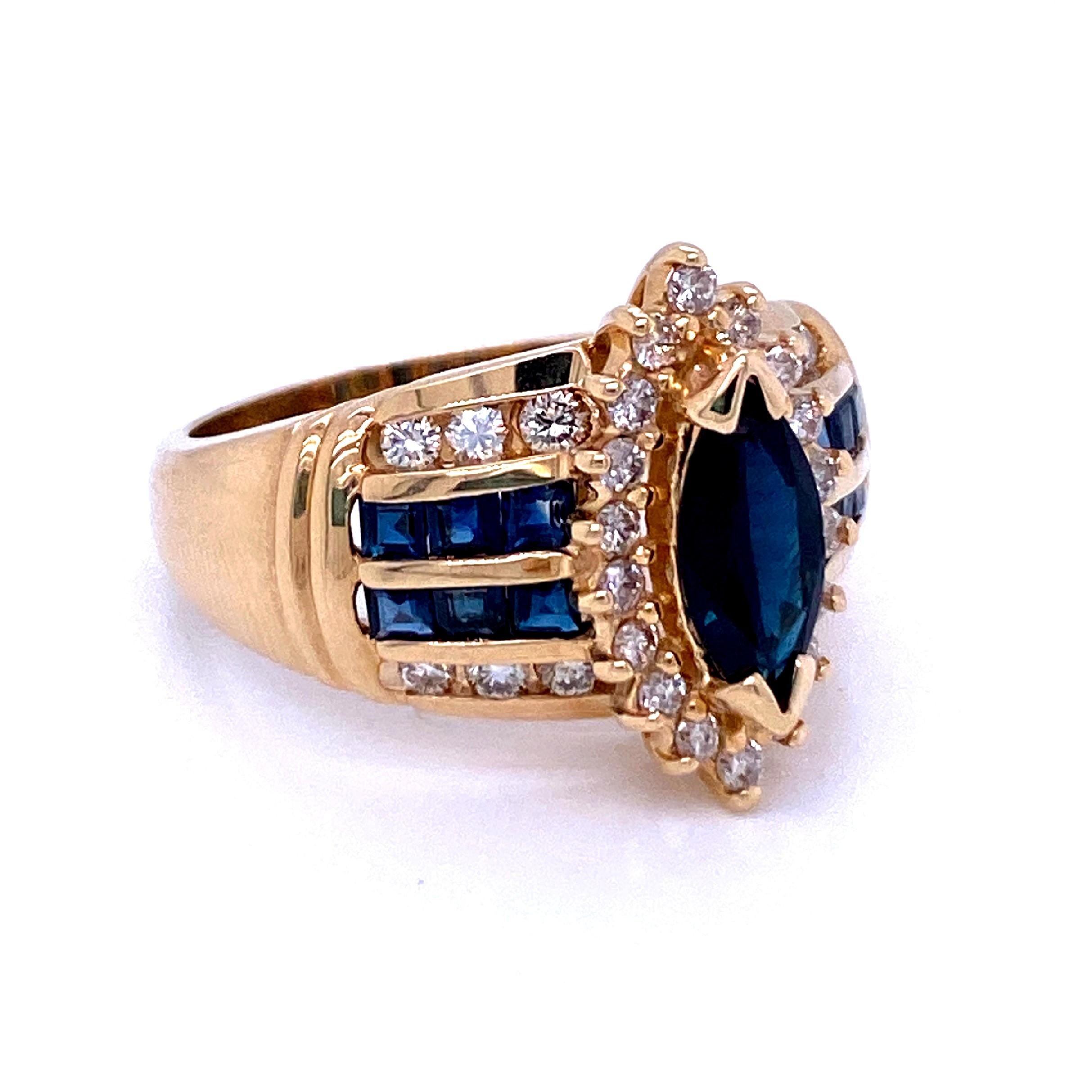 One 14 karat yellow gold Marquise cut natural blue sapphire, approximately 1.00 carat surrounded by a halo of eighteen 1.6mm light brown diamonds approximately 0.30 carat total weight  with SI1 clarity.  The halo sits above twelve 2mm square