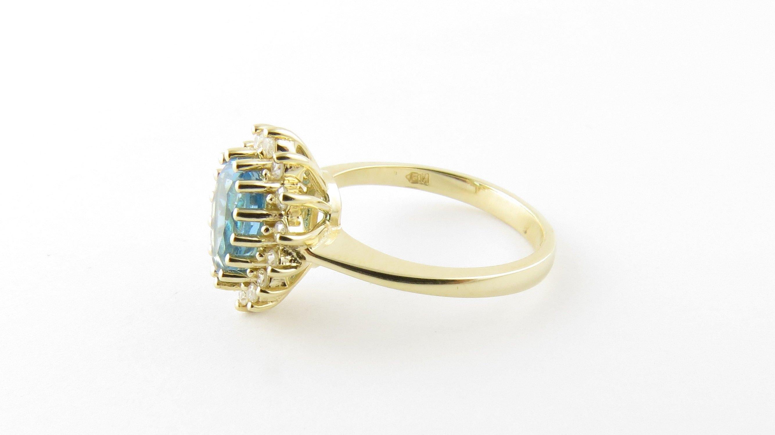 Vintage 14 Karat Yellow Gold Blue Topaz and Diamond Ring Size 6.75- This lovely ring features one pear shaped blue topaz (10 mm x 8 mm) surrounded by 14 round brilliant cut diamonds and set in classic 14K yellow gold. Top of ring measures 14 mm x 12