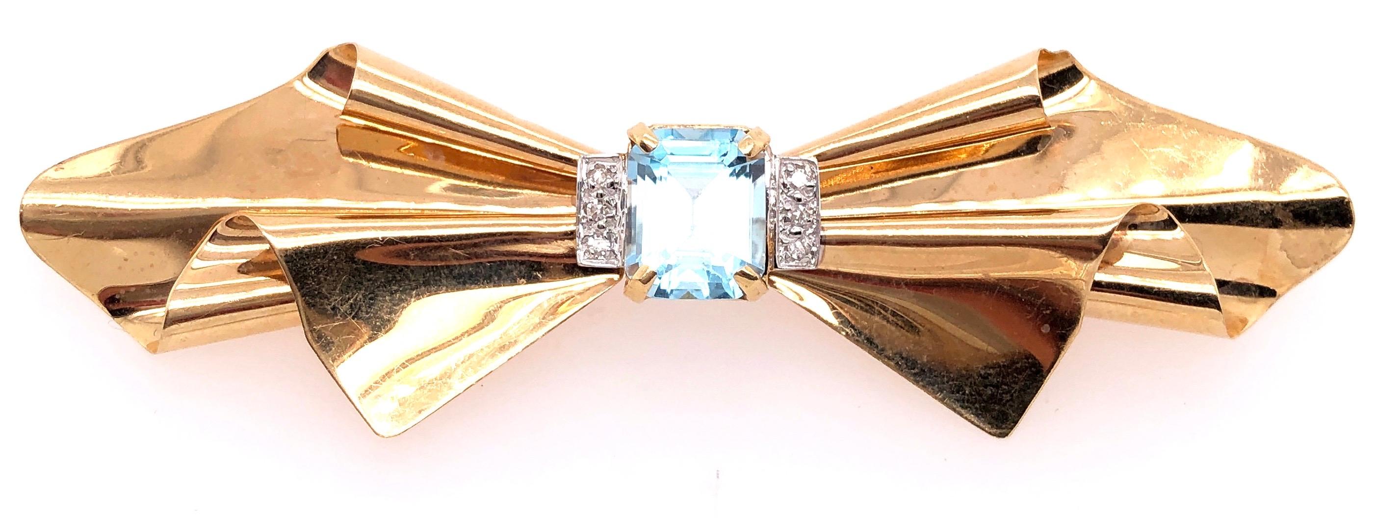 Modern 14 Karat Yellow Gold Bow Brooch with Blue Topaz and Diamond Accents For Sale