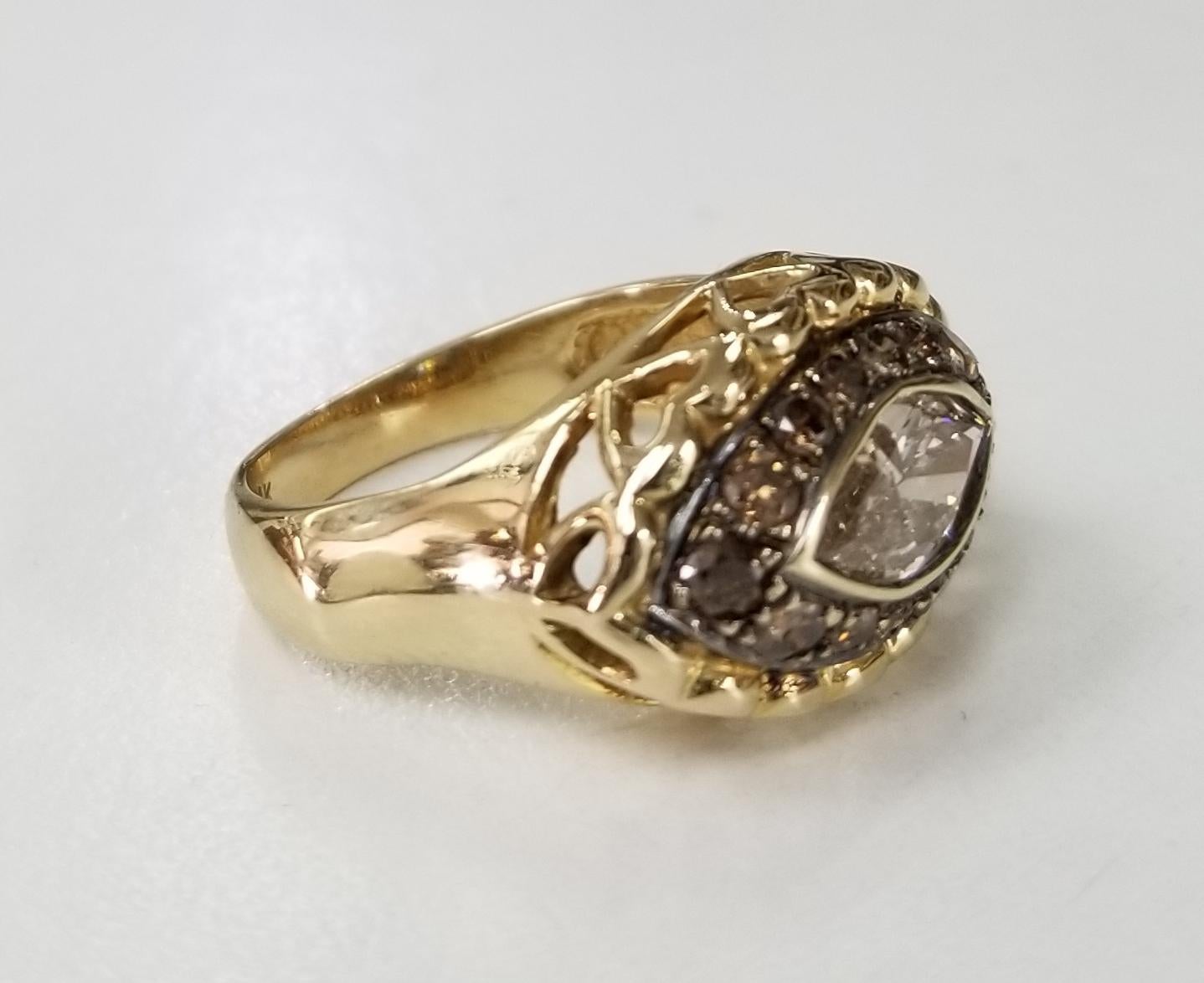 14k yellow gold brown diamond halo ring containing 1 marquise cut diamond weighing .78pts. also 14 round full cut diamonds weighing .60pts.  Top halo has been black rhodium.  This ring is a size 6 but we will size to fit for free.