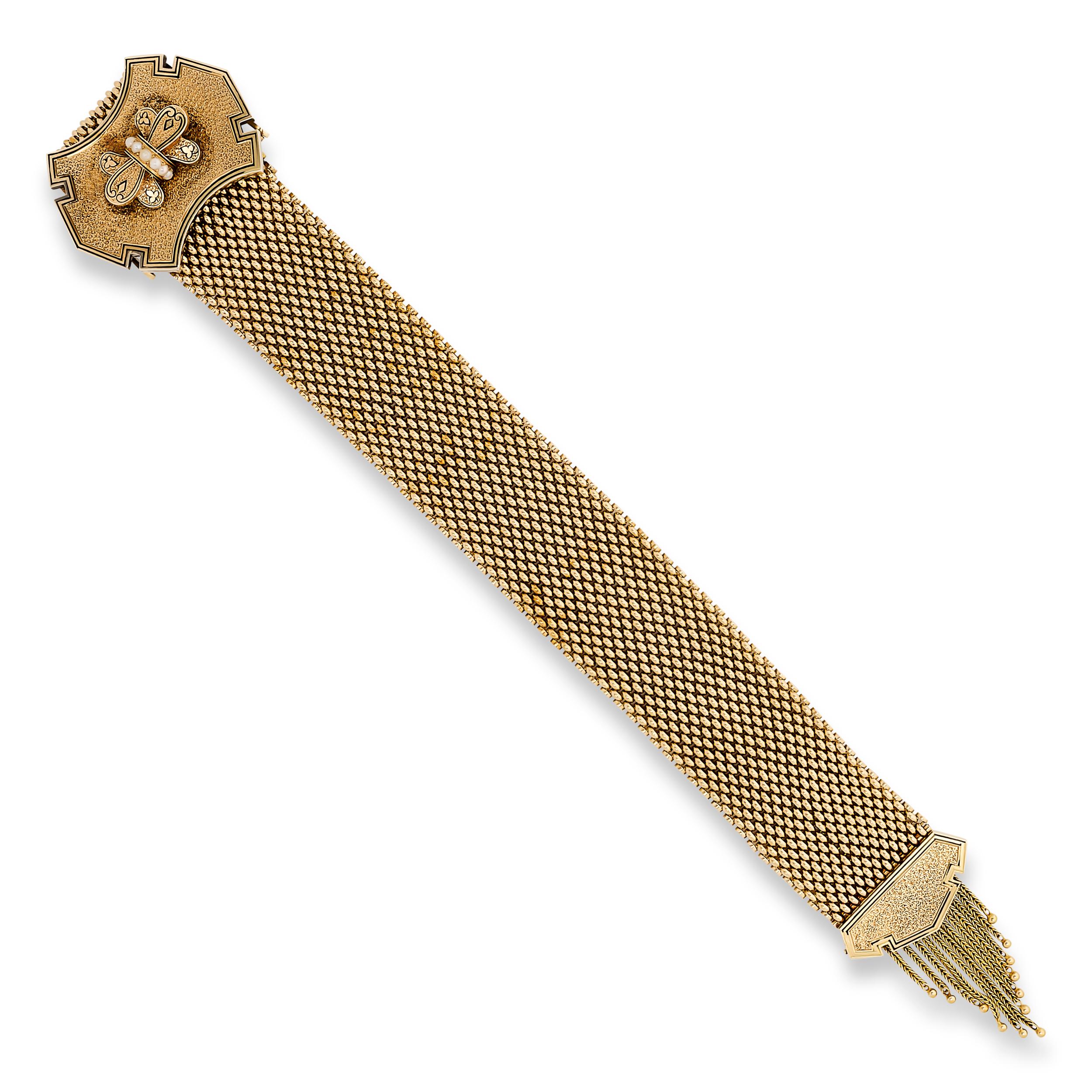 Cet étonnant bracelet à boucle en or présente une large bande de maille finement texturée, ancrée par une boucle centrale proéminente et ornementée d'une perle centrale, et finie par d'élégants glands à franges pour une touche de sophistication