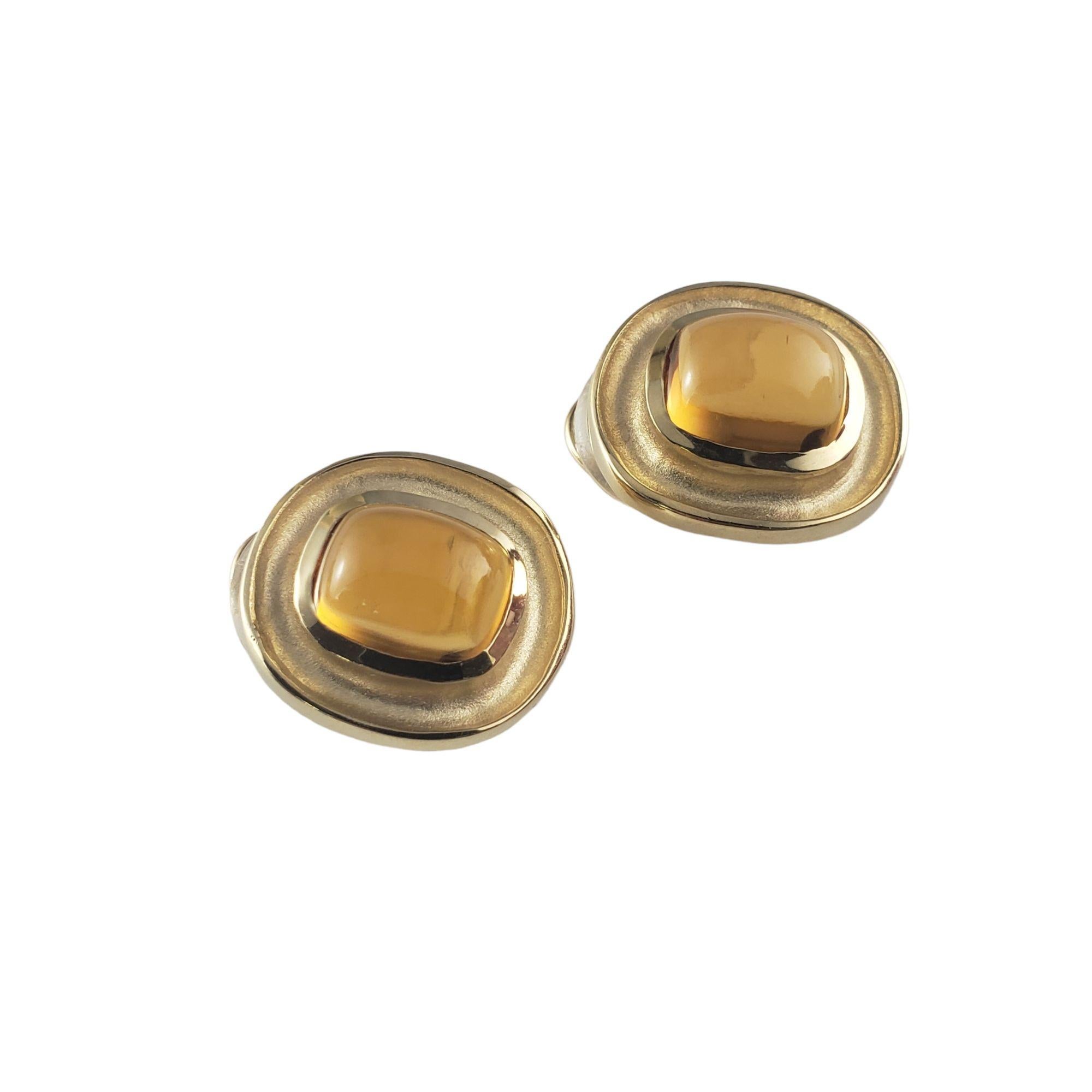 These stunning earrings each feature one cabochon citrine (11 mm x 9 mm) set in beautifully detailed 14K yellow gold.  Omega back closures.

Total citrine weight:  9.04 ct.

Size: 21 mm x 18 mm

Weight:  11.6 gr./  7.4 dwt.

Stamped:  14K

JAGi