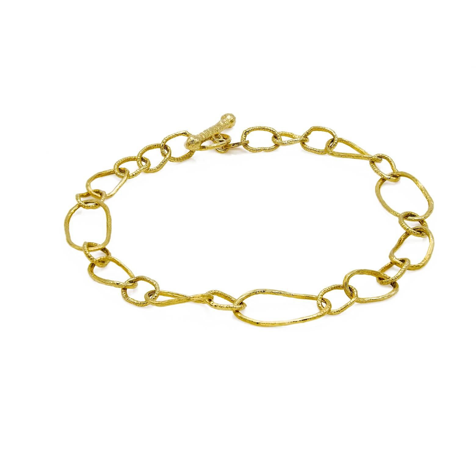 This architecturally designed bracelet with the different shapes of chain links and the alternating textures of each unique oval is absolutely stunning. The bright 14 karat yellow gold shines in thousands of directions with the artist's dedication