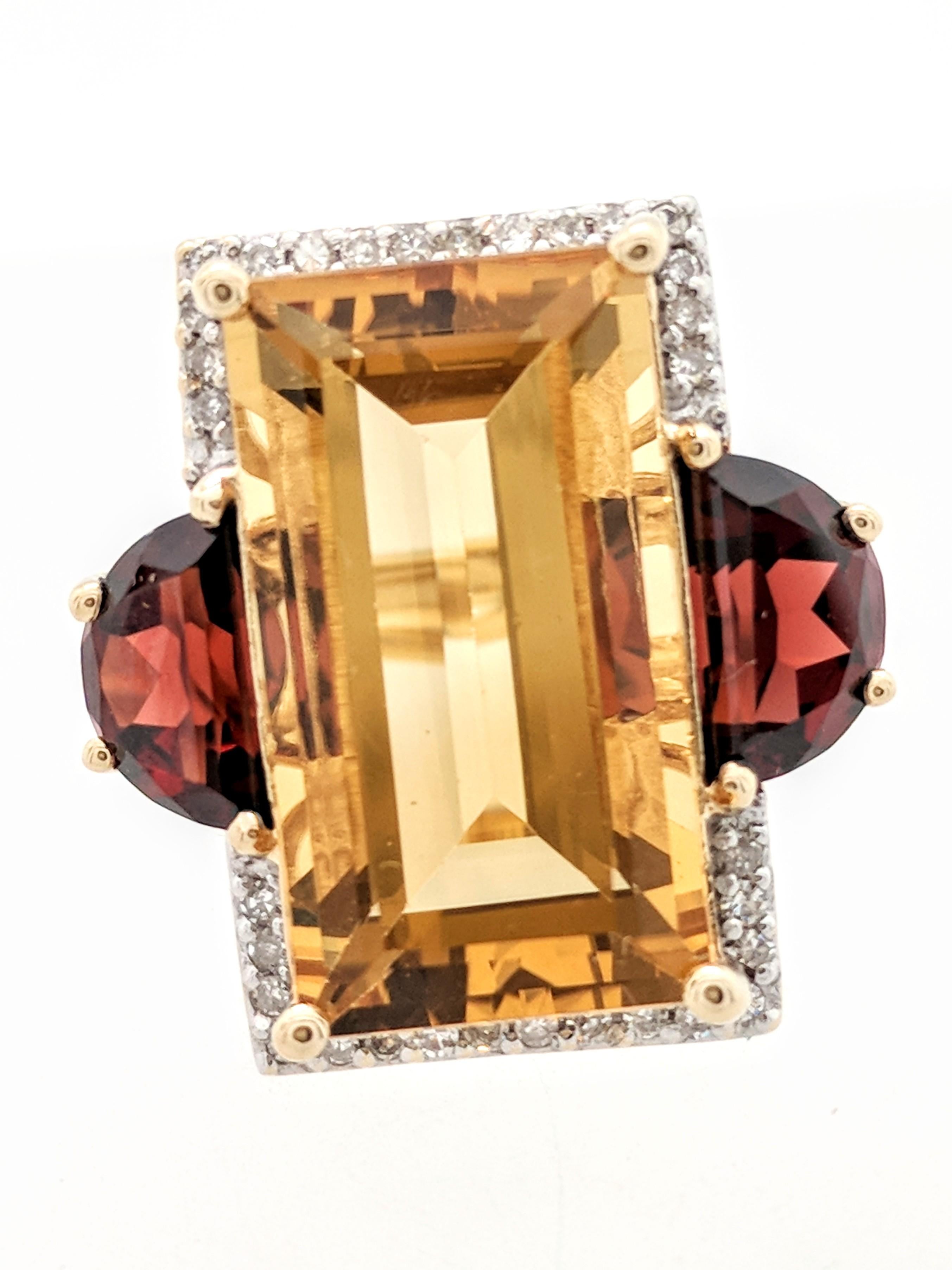 You are viewing a beautiful citrine, garnet and diamond right hand ring. Any woman would love to add this piece to their collection! This ring is crafted from 14k yellow gold and weighs 7.7 grams. It features approximately (1) 18x10mm emerald cut