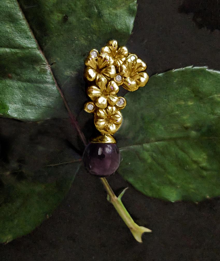 This Plum Blossom brooch is a unique sculptural piece made from 14 karat yellow gold, encrusted with 5 round diamonds and a removable cabochon smoky quartz drop. We use top natural diamonds, VS clarity and F-G color, and work with a German gems