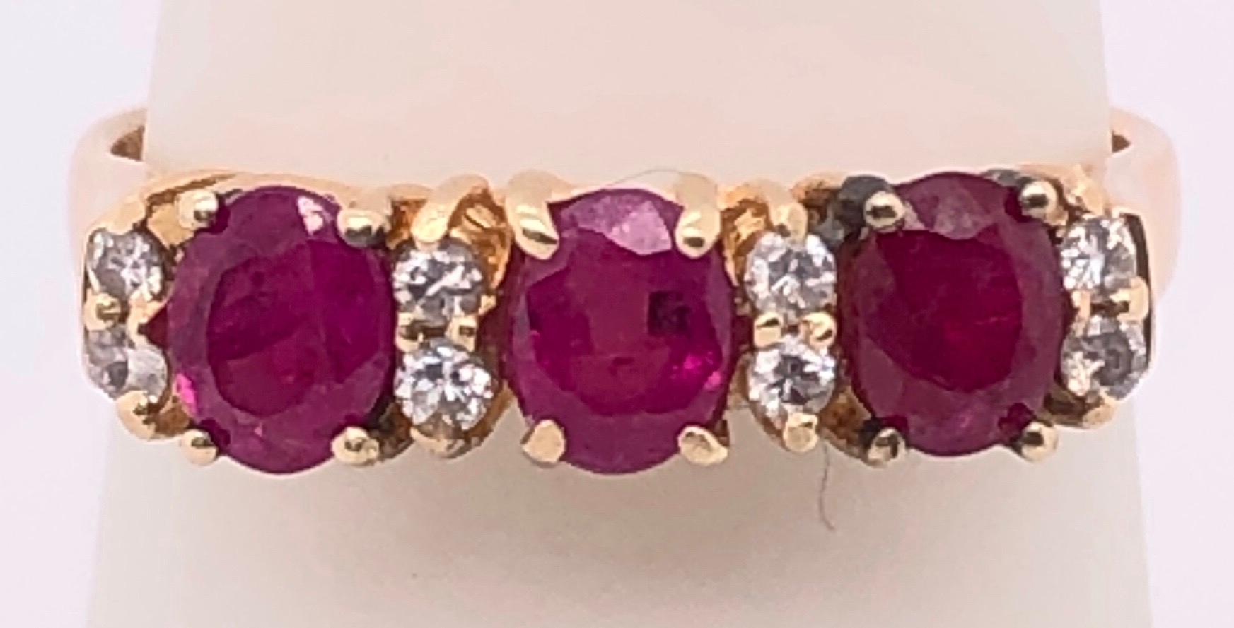 14 Karat Yellow Gold Contemporary Ring with Three Round Ruby's and Diamonds .
Size 7
3 grams total weight.