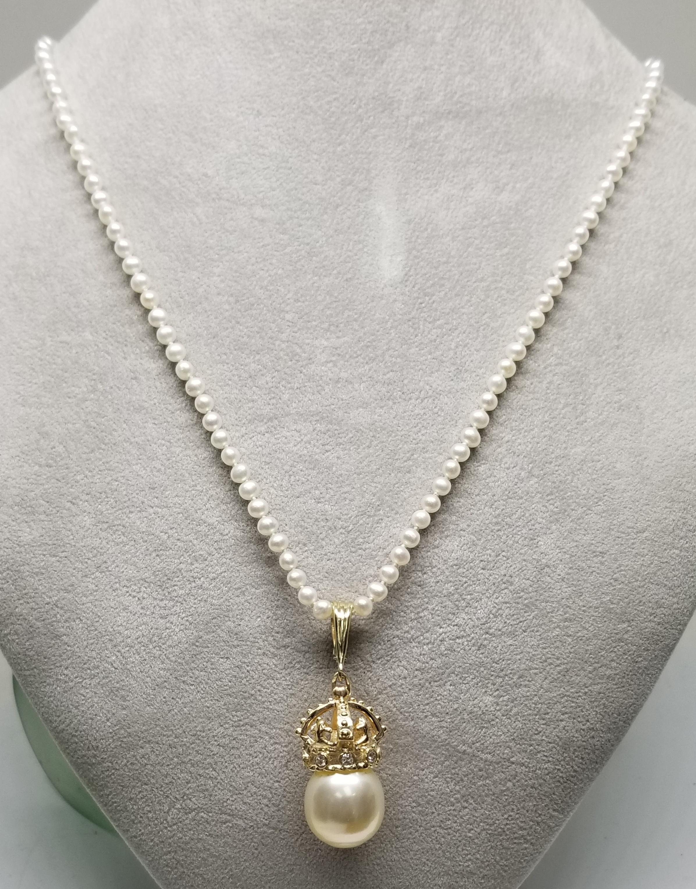 14k yellow gold crown with diamonds and south sea pearl pendant, containing 15mm south sea pearl and 8 round full cut diamonds; color 