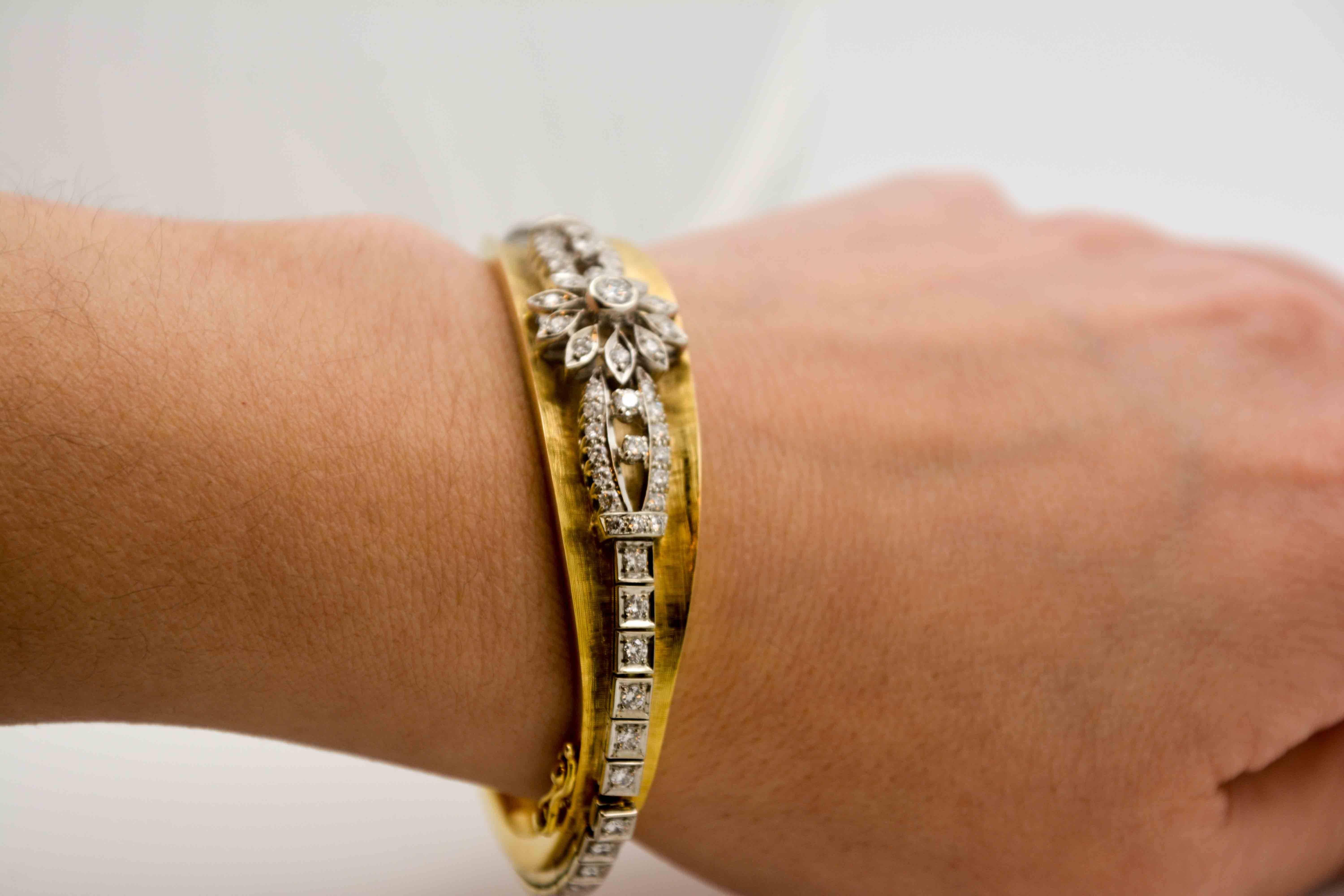 This 14 Karat Yellow gold bracelet is so easy to love. Like the so-welcomed hint of spring with diamonds set in a flower shape, this bangle bracelet is light, yet it has great character with diamonds set in 14 karat white gold cascading down each