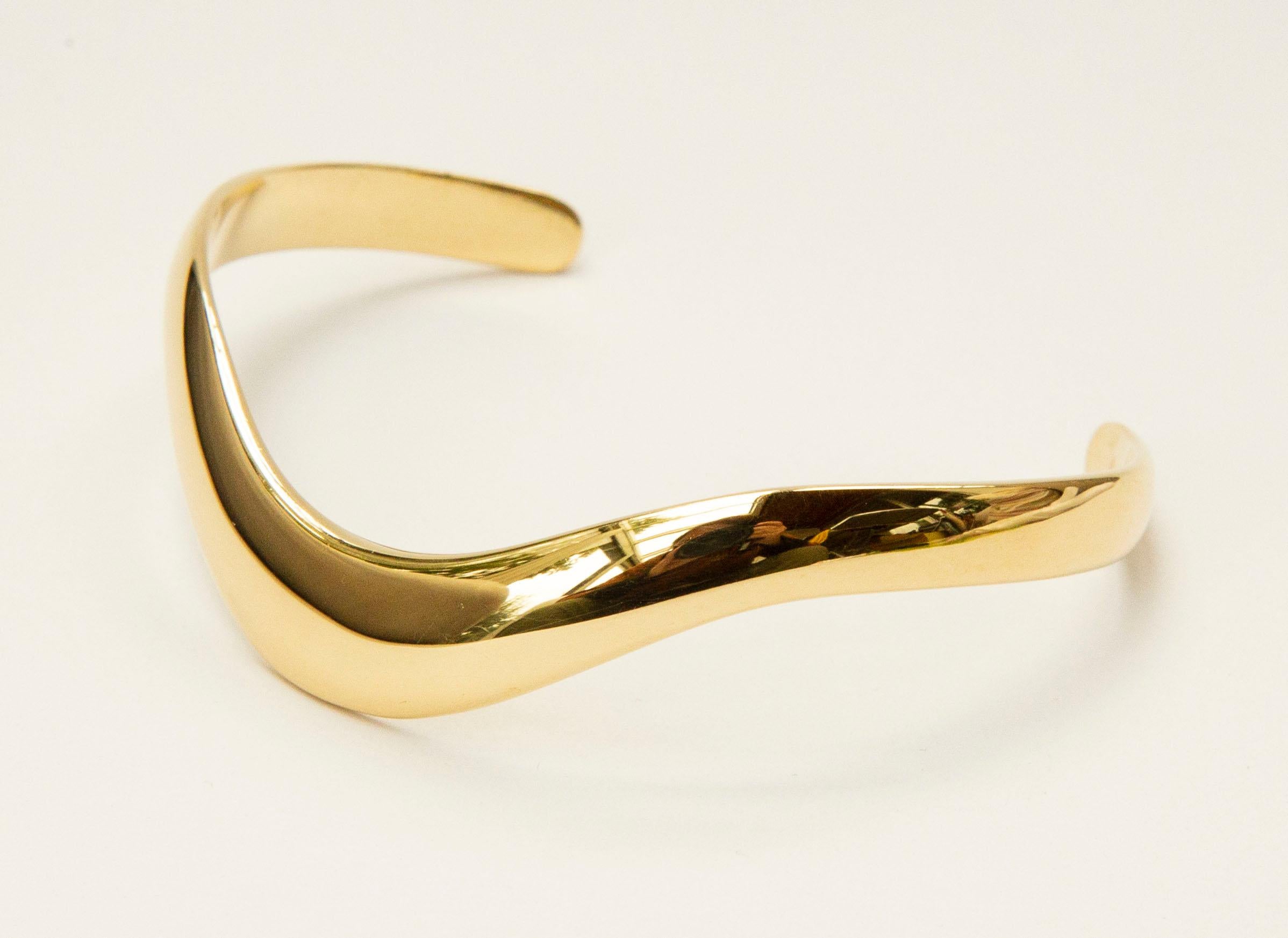 Un bracelet manchette en  Or jaune massif 14 carats. Le bracelet présente un design moderne et minimaliste.  Design/One. Il peut être porté tous les jours ou lors d'occasions spéciales. 
La largeur du bracelet varie de 10,5 mm au milieu supérieur à