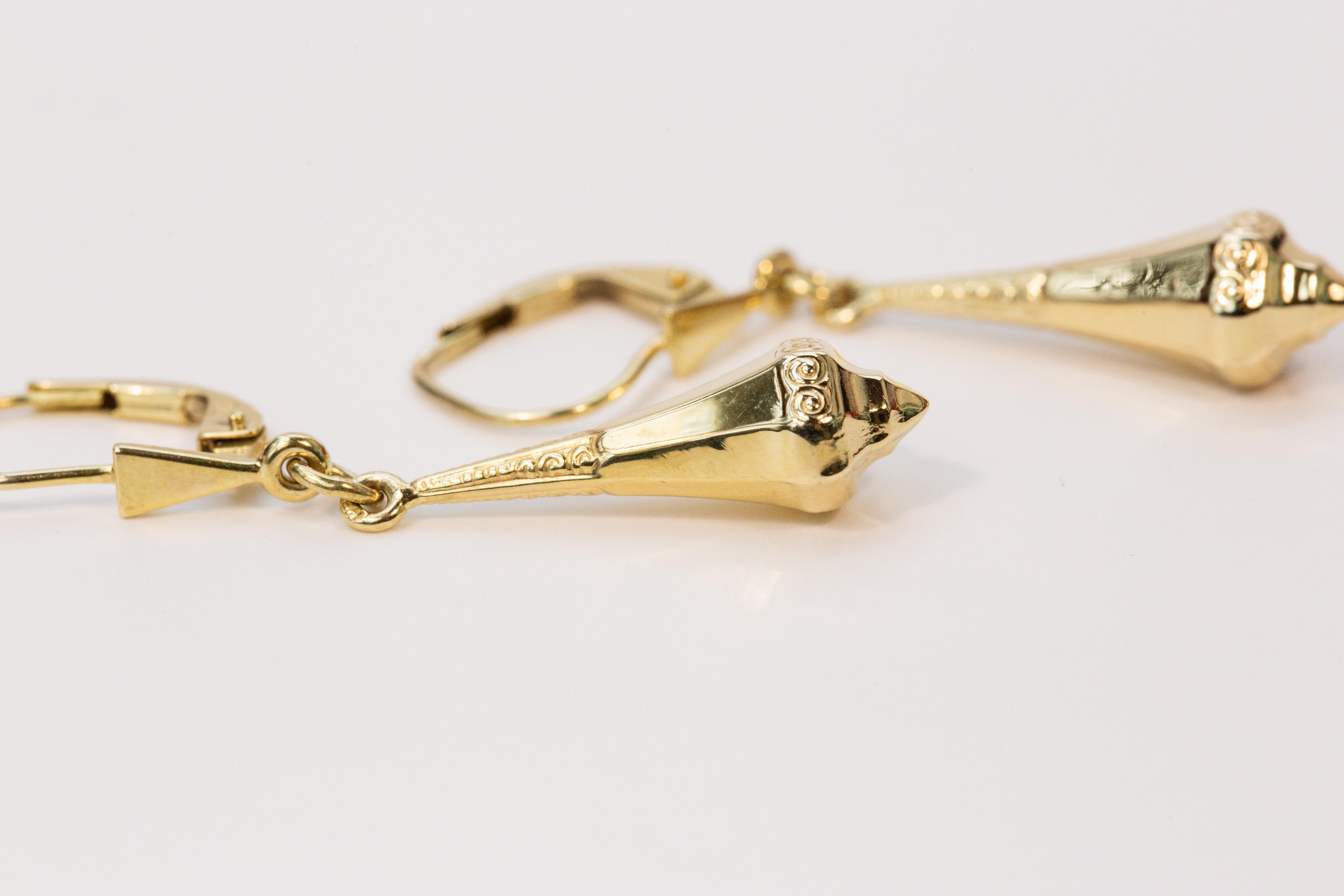 Un paio di orecchini pendenti vintage in oro giallo 14 carati realizzati a metà del XX secolo. Gli orecchini hanno una forma esagonale, affusolata verso la parte superiore. Inoltre, gli orecchini sono decorati con raffinati motivi geometrici nella