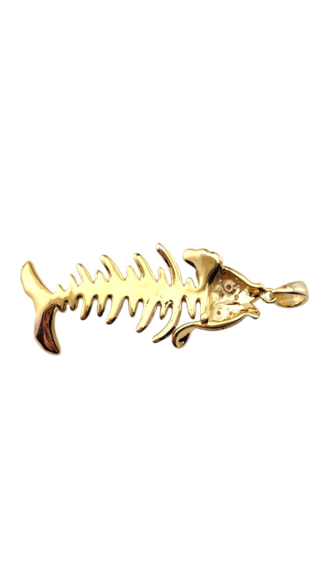 14k Yellow Gold Diamond Fish Skeleton Pendant-

This 14k yellow gold fish skeleton pendant features intricate detailing that highlights the delicate structure of the fish bones. Diamonds accent the head as well as a purple stone for eye. Its unique