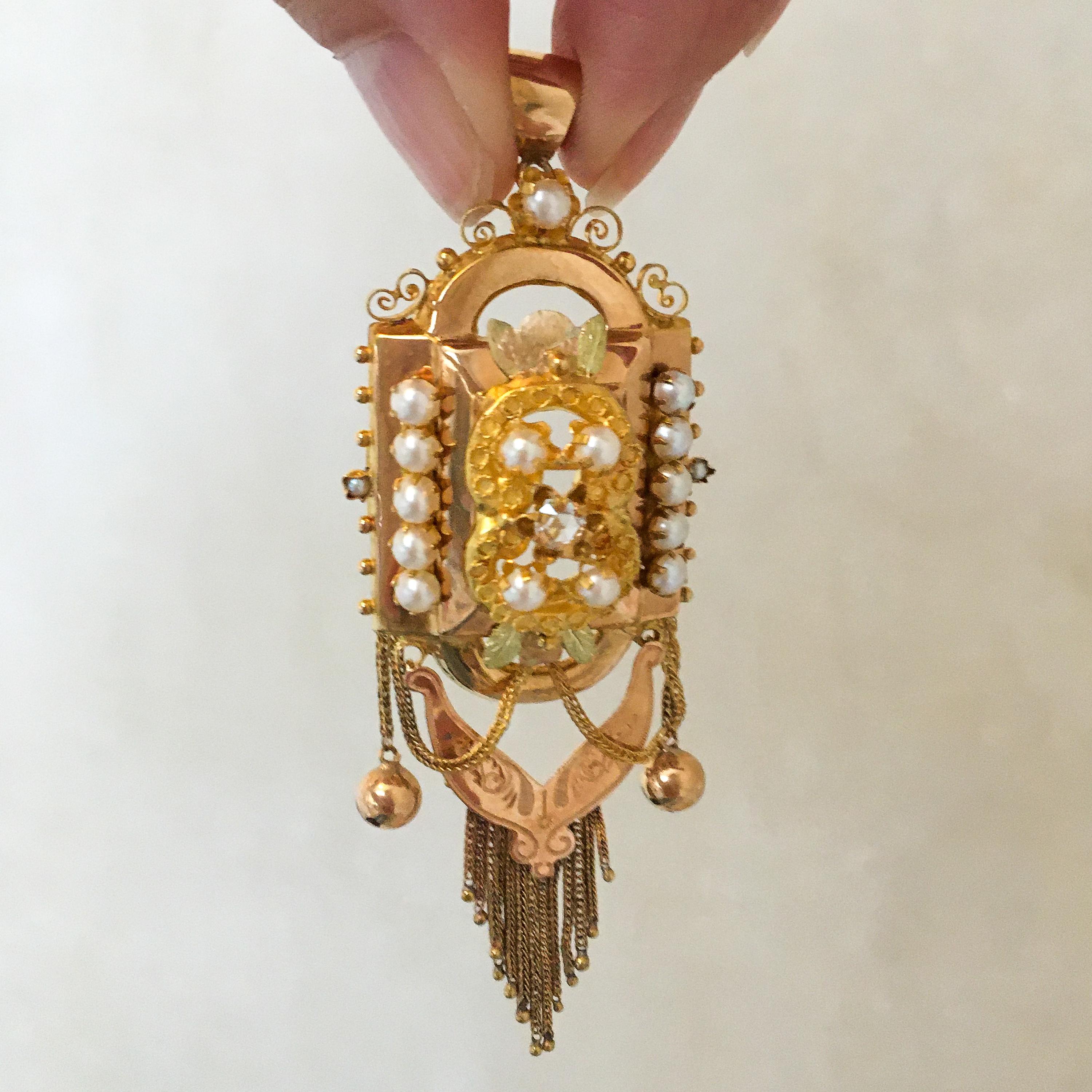 This is an antique 19th century gold ornate pendant and brooch created with seed pearls and lovely tassels. The design of this piece is magnificent, set with a double C-shape, leaf motifs and beading made of 14 karat yellow gold and rose gold. The