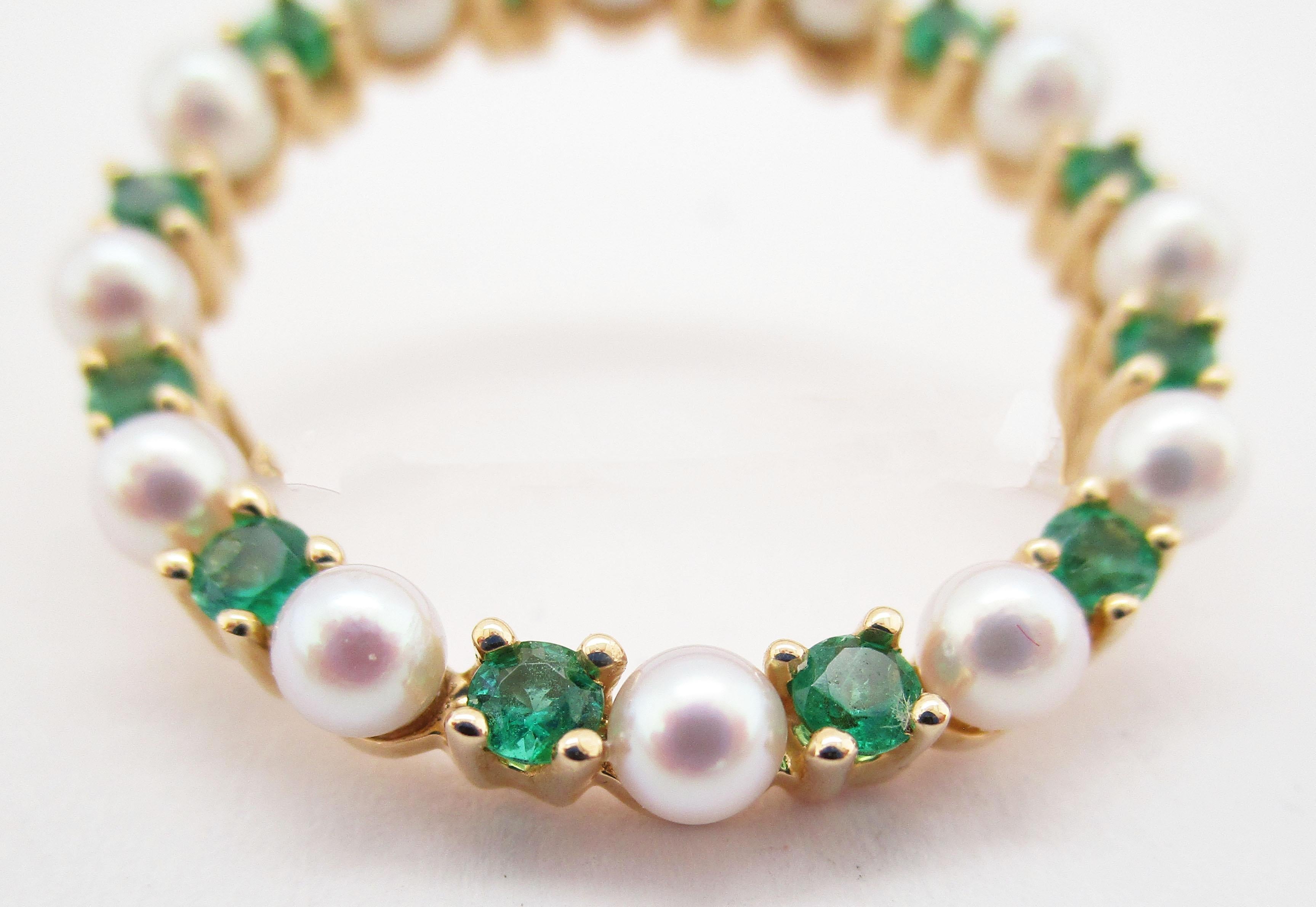 This is an absolutely beautiful mid-century circle pin with a gorgeous array of pearls and emeralds set into 14k yellow gold. The pearls are stunning-like shimmery silver round mirrors! The luster of the pearls is the perfect contrast for the