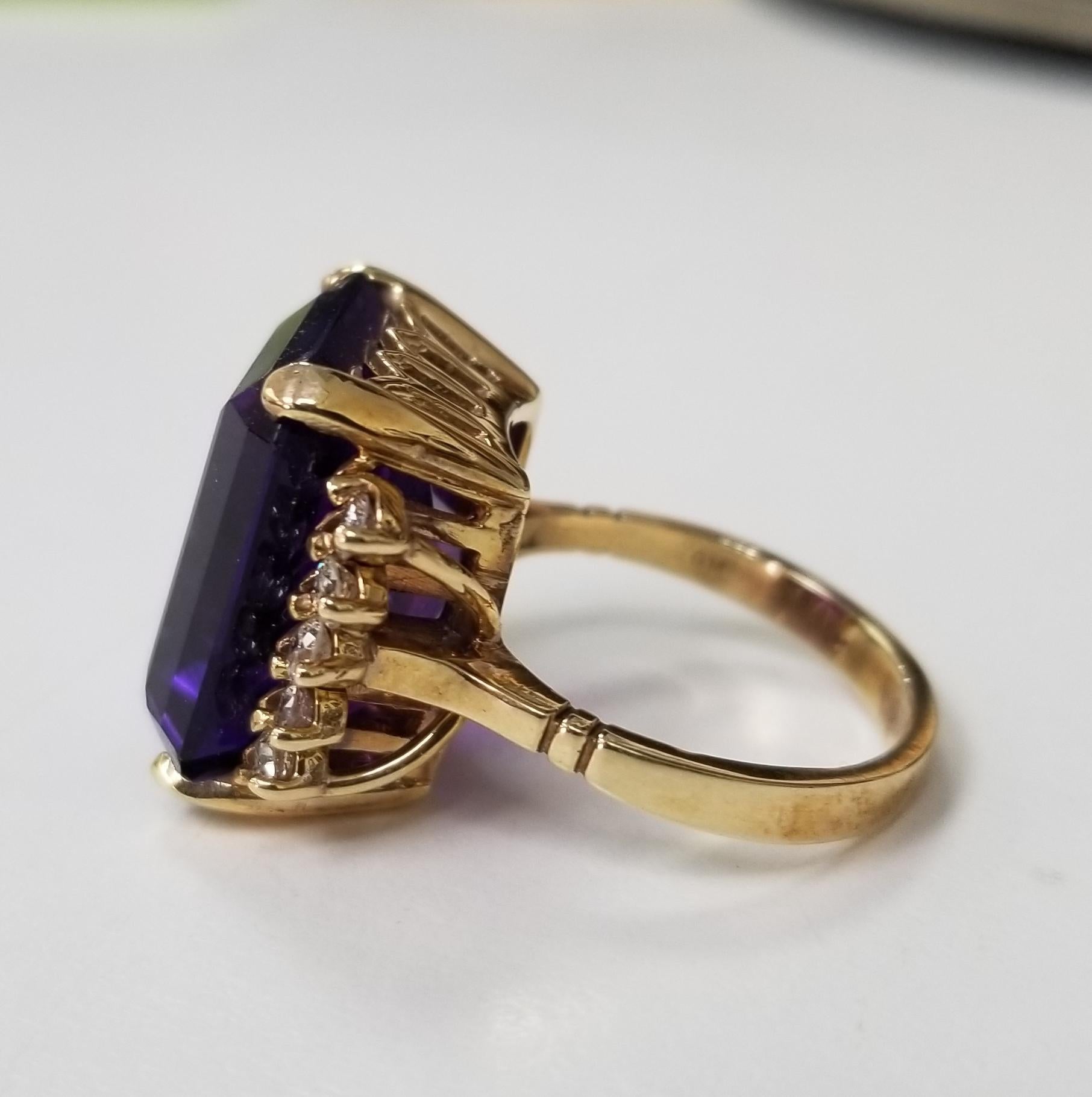 14k yellow gold amethyst and diamond ring, containing 1 emerald cut  weighing 14cts. and 10 round diamonds weighing .55pts.  This ring is a size 5.75 but we will size to fit for free.