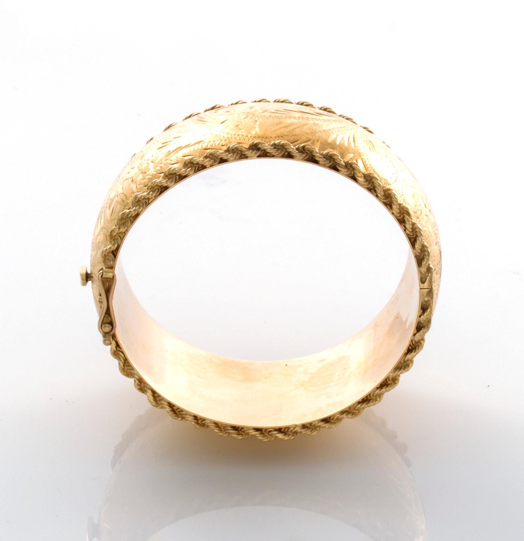 The bracelet is hand crafted in 14 Karat Yellow Gold etched on the outside convex area and flat gold on the inside of the bracelet. There is also a gold rope attached to the top and bottom border of the bracelet. It should fit a 6.75