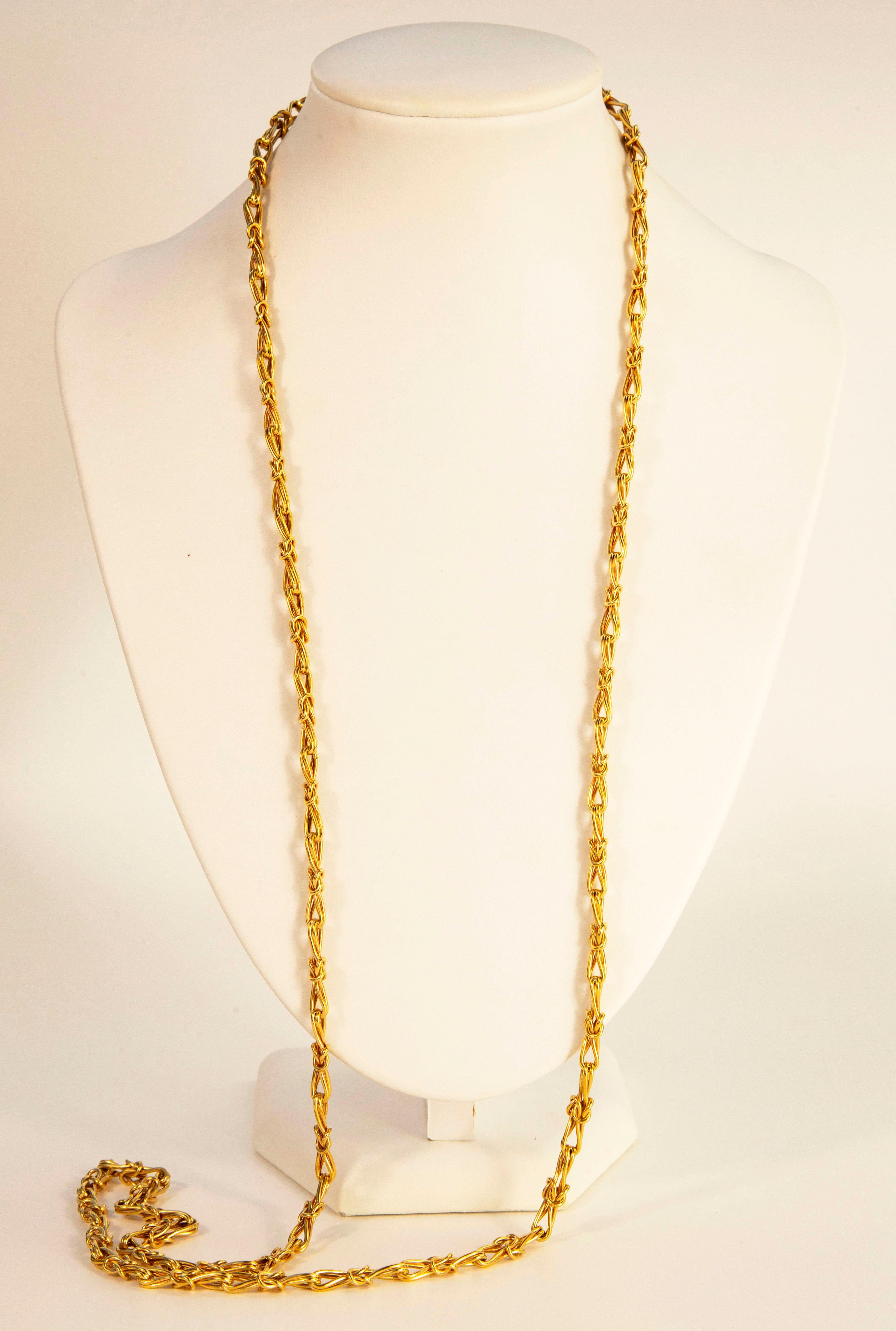 A 14 karat yellow gold fantasy link necklace, with stylized buttons loop motifs.  The necklace was manufactured in the late 20th century in the Netherlands. 
The necklace does not have a closure, but due to its imposing length  of 94 centimeters, it