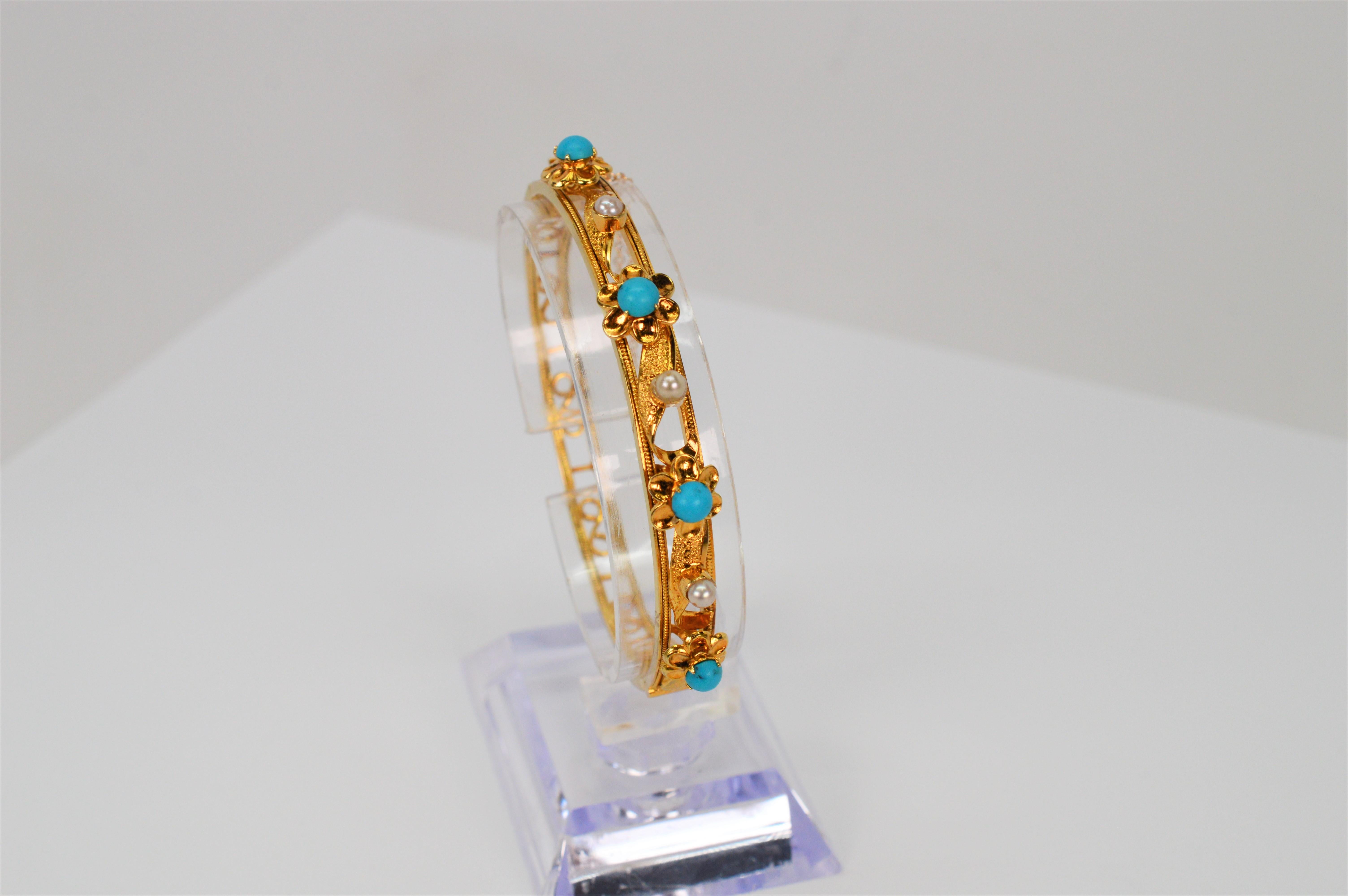 In 14 karat yellow gold, open decorative scroll work with floral inspired gold appliques are hand assembled across the placket of this 
appealing bangle bracelet. Adding color and artistic interest are pretty floral buds accented with 4mm turquoise