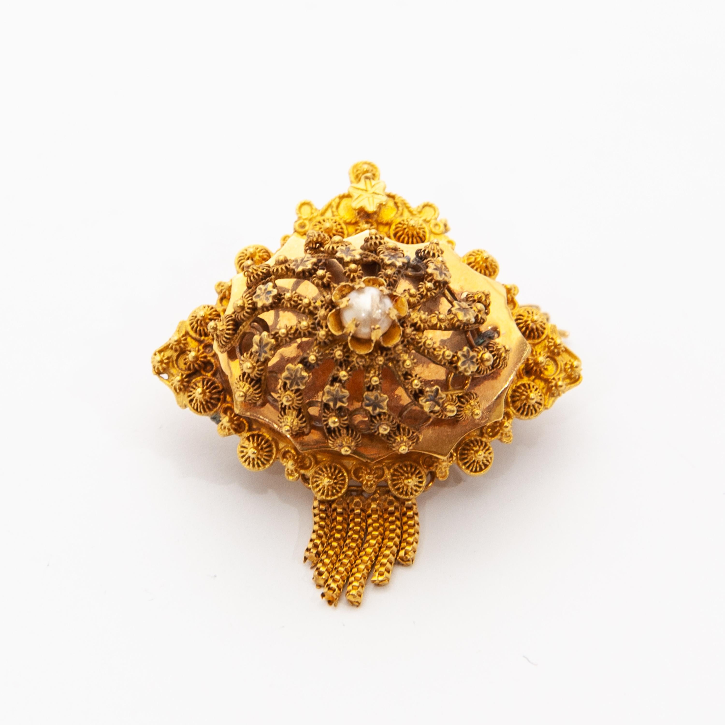 Dieses antike Schmuckset aus 14 Karat Gelbgold aus dem späten 19. Jahrhundert besteht aus einem Paar Ohrringe und einer Brosche. Diese Juwelen sind sehr fein mit Filigran- und Cannetille-Arbeiten ausgearbeitet und in der Mitte mit einer Perle