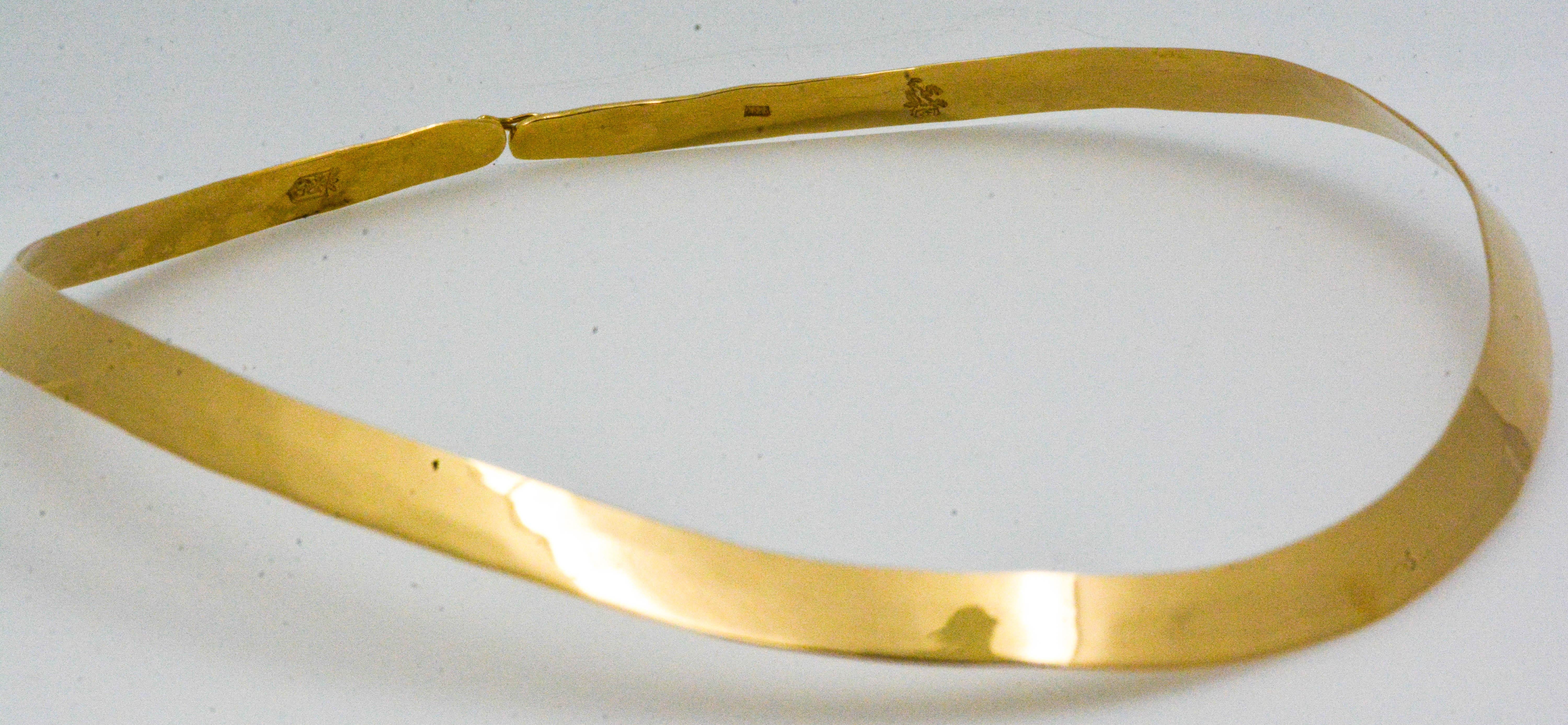 The magical elegance of 14 karat gold is captured in this handmade hammered finish collar necklace. Measuring 7.24 mm wide, this admirable flat wire collar is lightweight and extremely comfortable. Glistening 14 karat yellow gold will enhance any