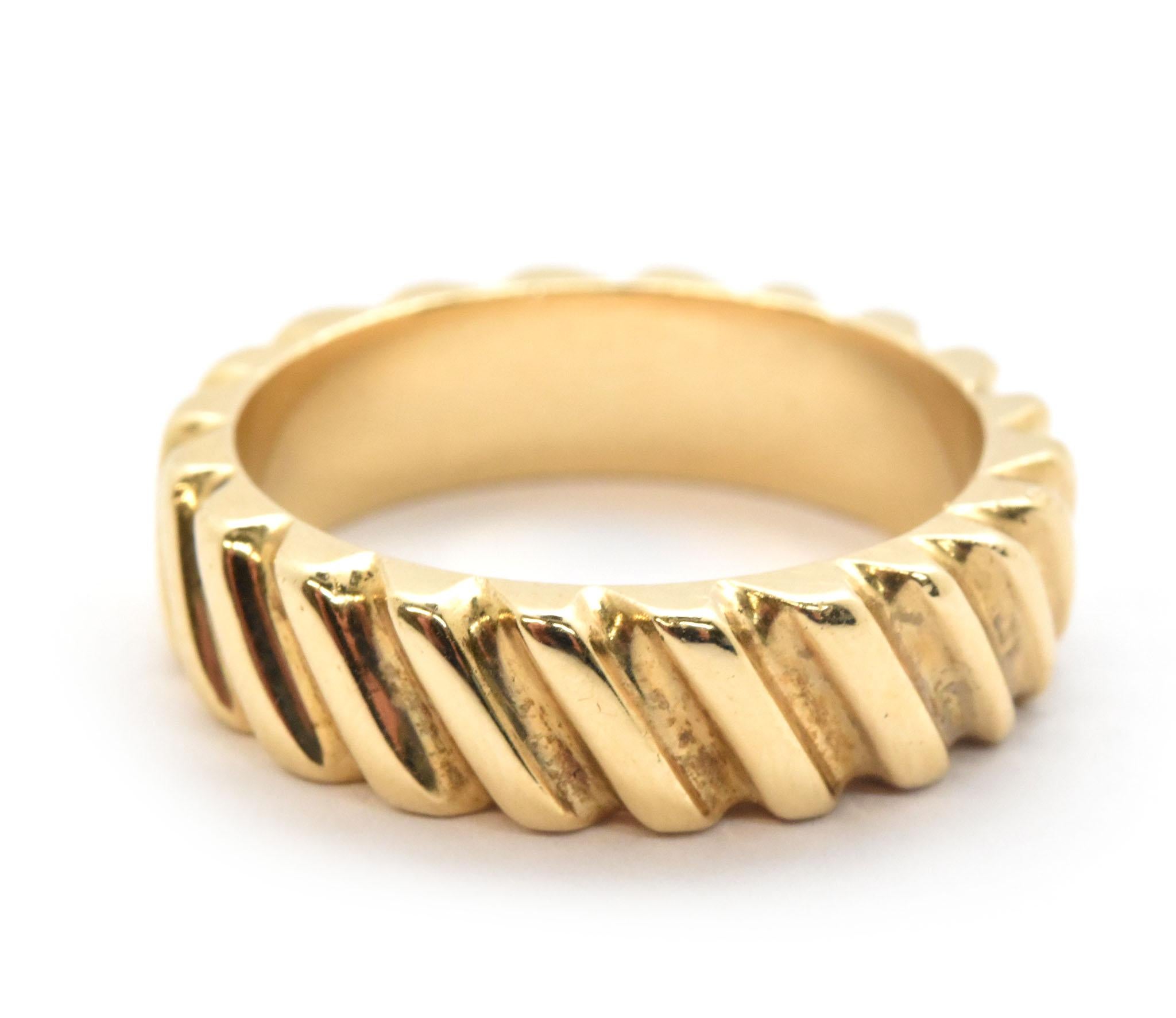 This wedding band is made in solid 14k yellow gold. It measures 6mm wide, and has diagonal fluting around for a unique look. The ring weighs 8.9 grams, and it is a size 8.5.