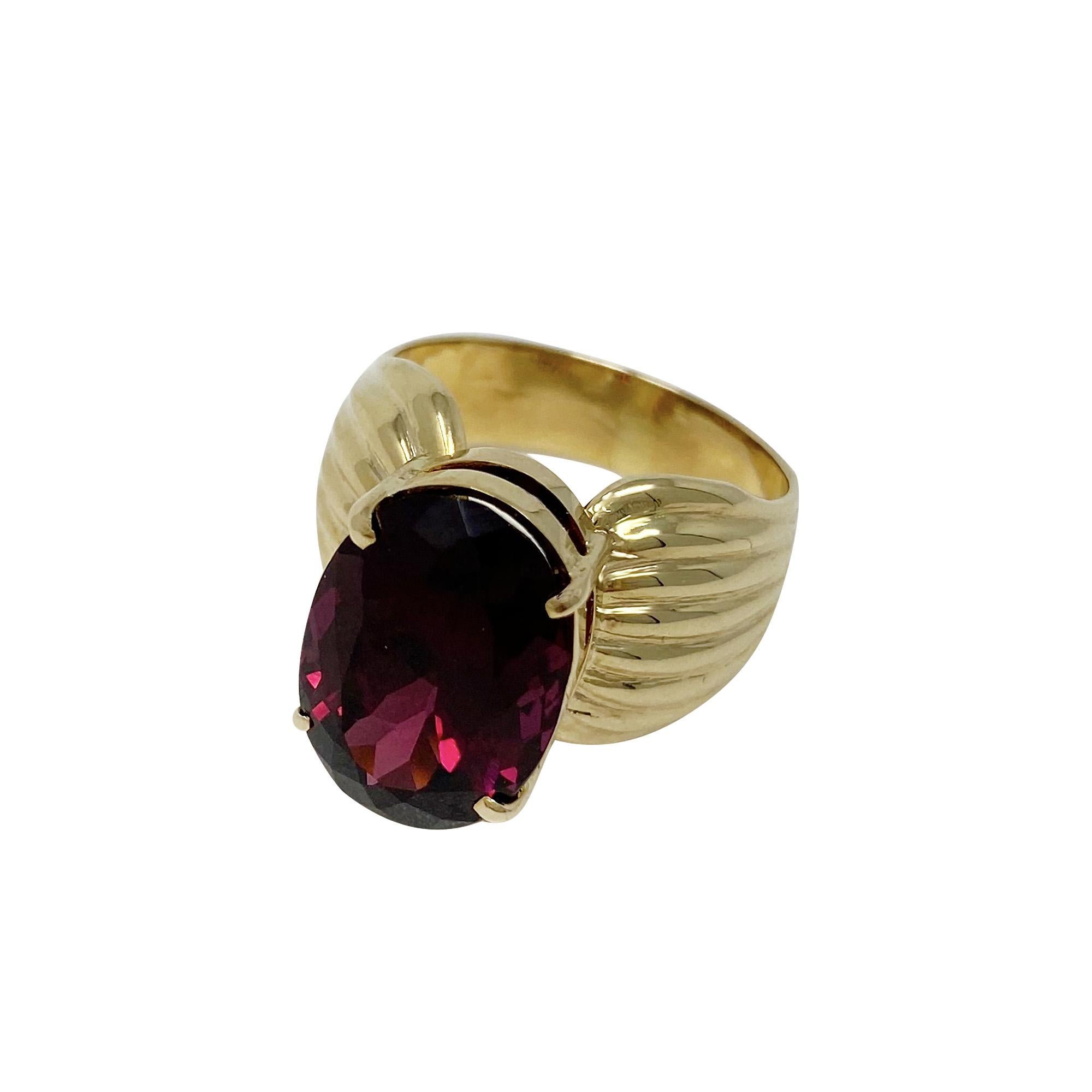 A great statement piece and so very light and comfortable on the finger!  This 14 karat, yellow gold, ribbed mounting is centered with one prong-set, oval-shaped garnet and is a size 7 1/2.