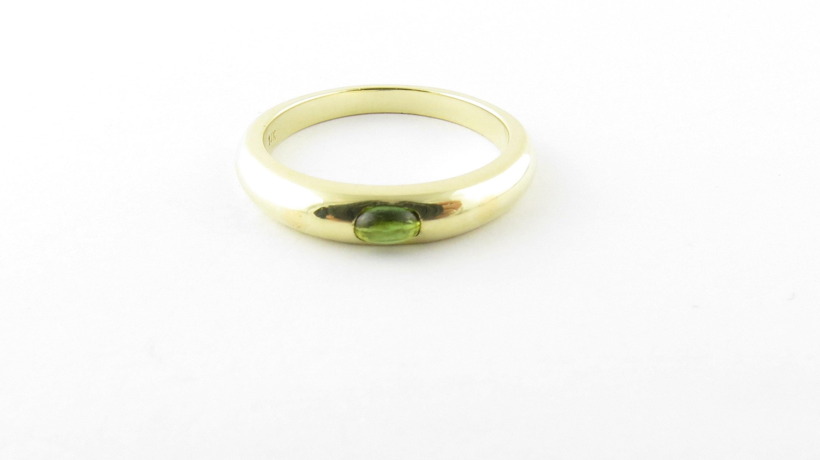 Vintage 14 Karat Yellow Gold Genuine Cabochon Peridot Stackable Ring Size 8.5. This elegant ring features one genuine cabochon peridot (5 mm x 3 mm) set in a polished 14K yellow gold band. 
Ring Width: 4 mm. Shank: 2 mm.

Available matching