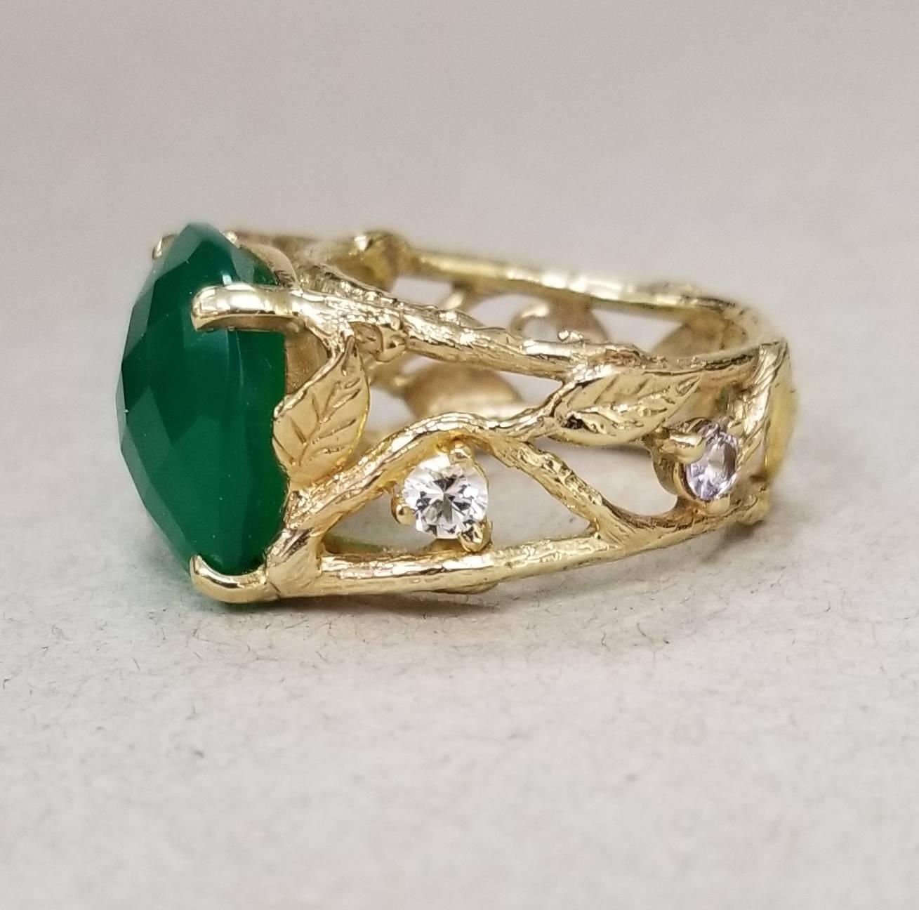 14k yellow gold Gresha signature bark and leaf ring with a cushion checkered board cut green onyx 15 x 15mm, also 4 round white sapphires weighing .55pts. 
*this design is ours and can be created in any other form; ring, necklace, bracelet, or