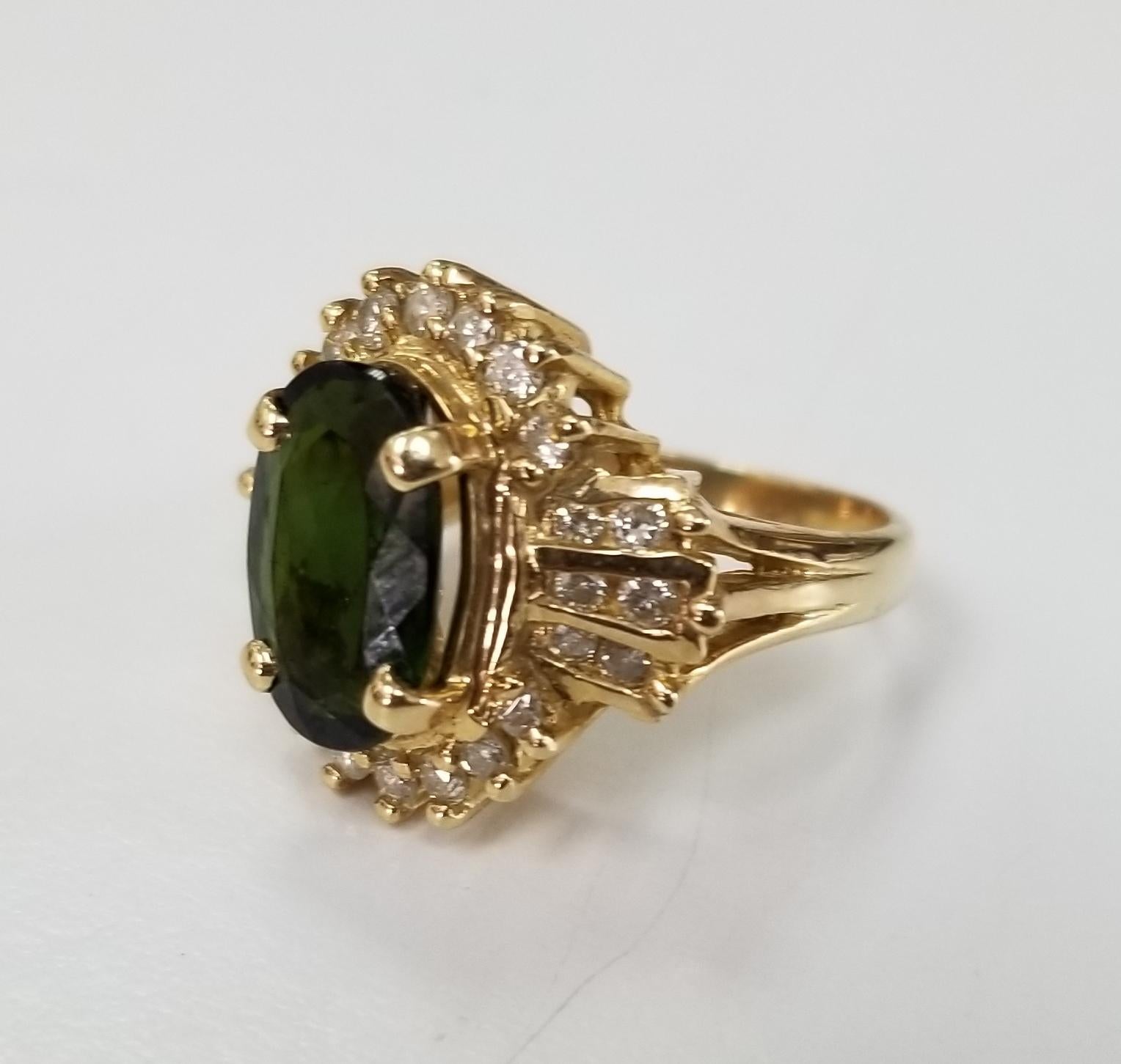 14k yellow gold Green Tourmaline and diamond ring, containing 1 oval cut tourmaline weighing 2.67cts. and 26 round full cut diamonds of very fine quality weighing .60pts.  This ring is a size 5 but we will size to fit for free.