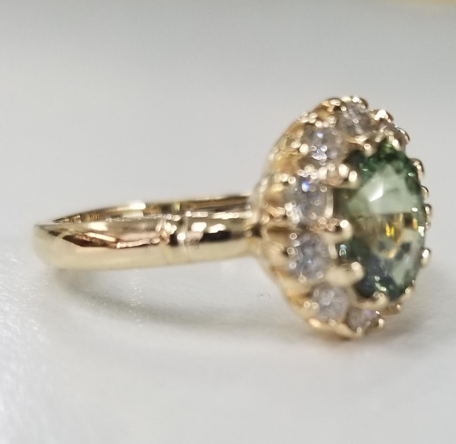 14 karat yellow gold Green Sapphire diamond halo ring, containing 1 oval green sapphire of gem quality weighing 1.92cts.  and 10 round full cut diamonds of very fine quality weighing .55pts.  This ring is a size 7 but we will size to fit for free.