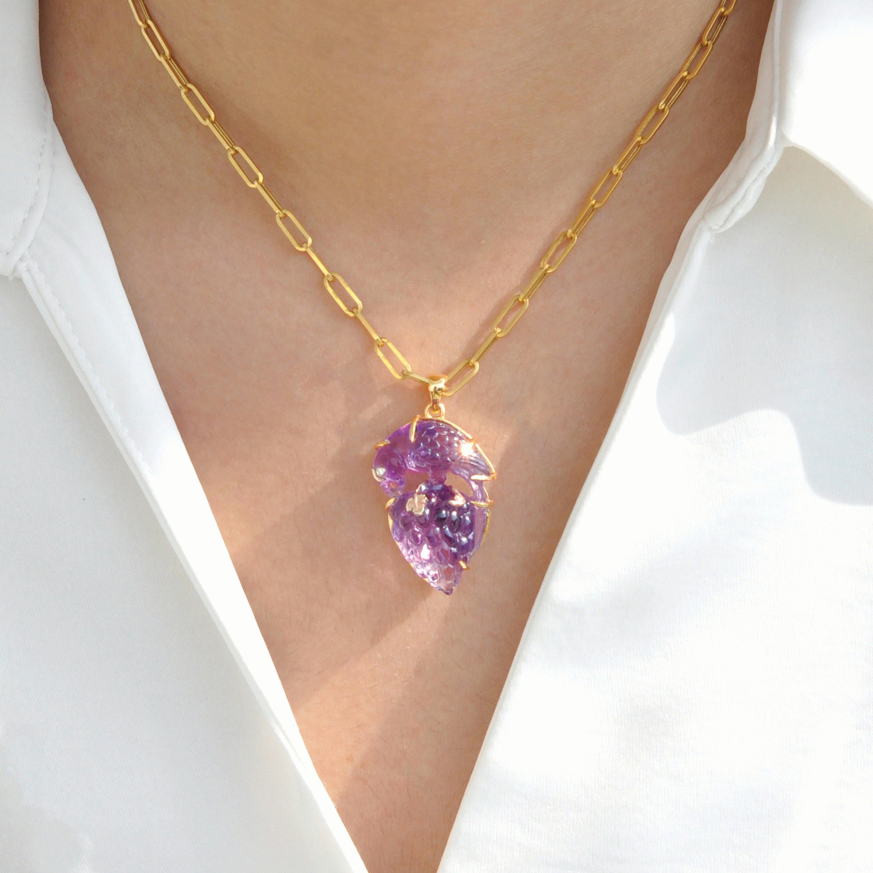 This exquisite 14 Karat Yellow Gold pendant is a remarkable work of art, designed to captivate nature lovers and jewelry enthusiasts alike. The focal point of this unique piece is a hand-carved amethyst gemstone weighing 34.34 carats, intricately