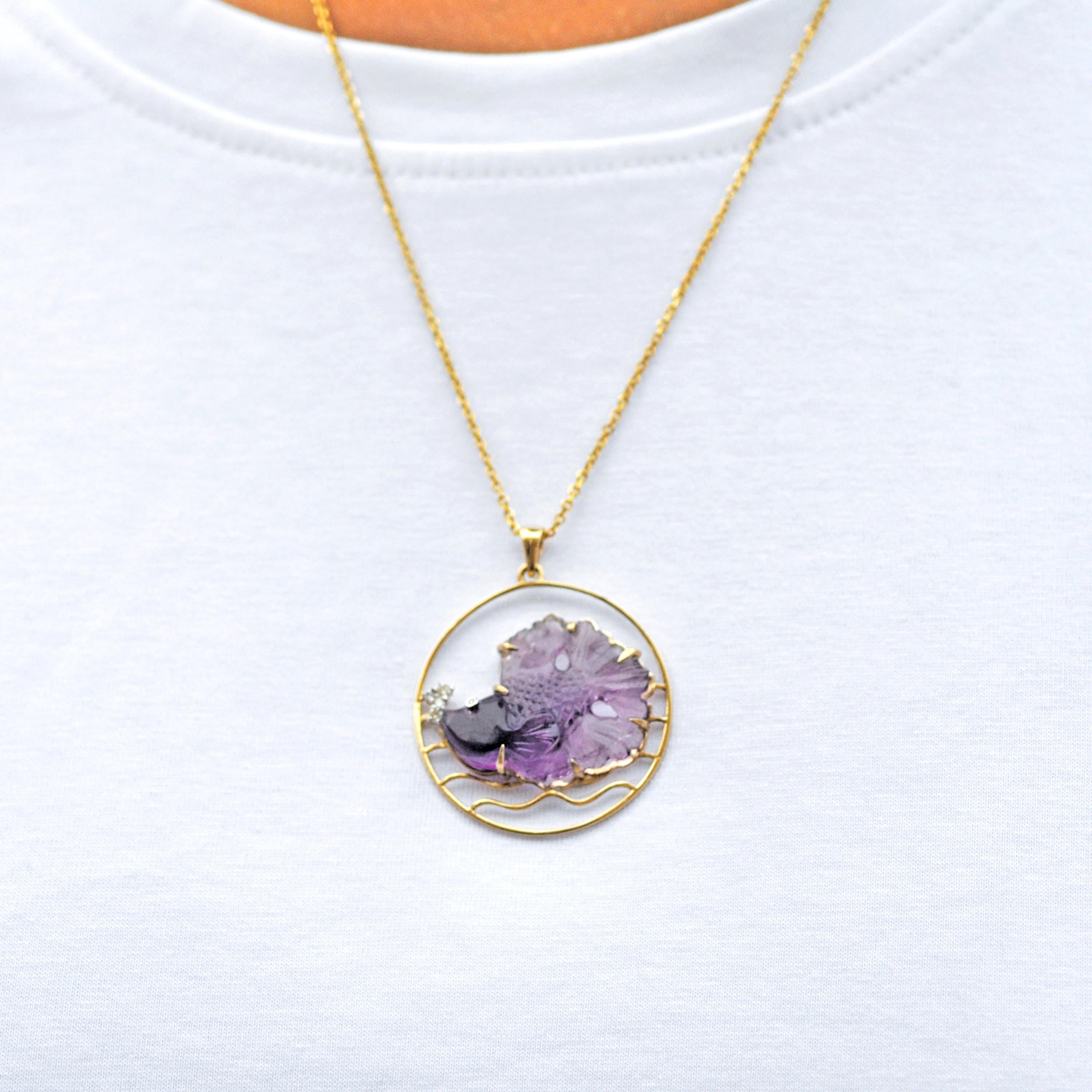 This enchanting 14 Karat Yellow Gold pendant necklace is a true testament to the beauty of nature and the artistry of fine craftsmanship. The centerpiece of this unique design is a hand-carved amethyst gemstone weighing 18.17 carats, intricately