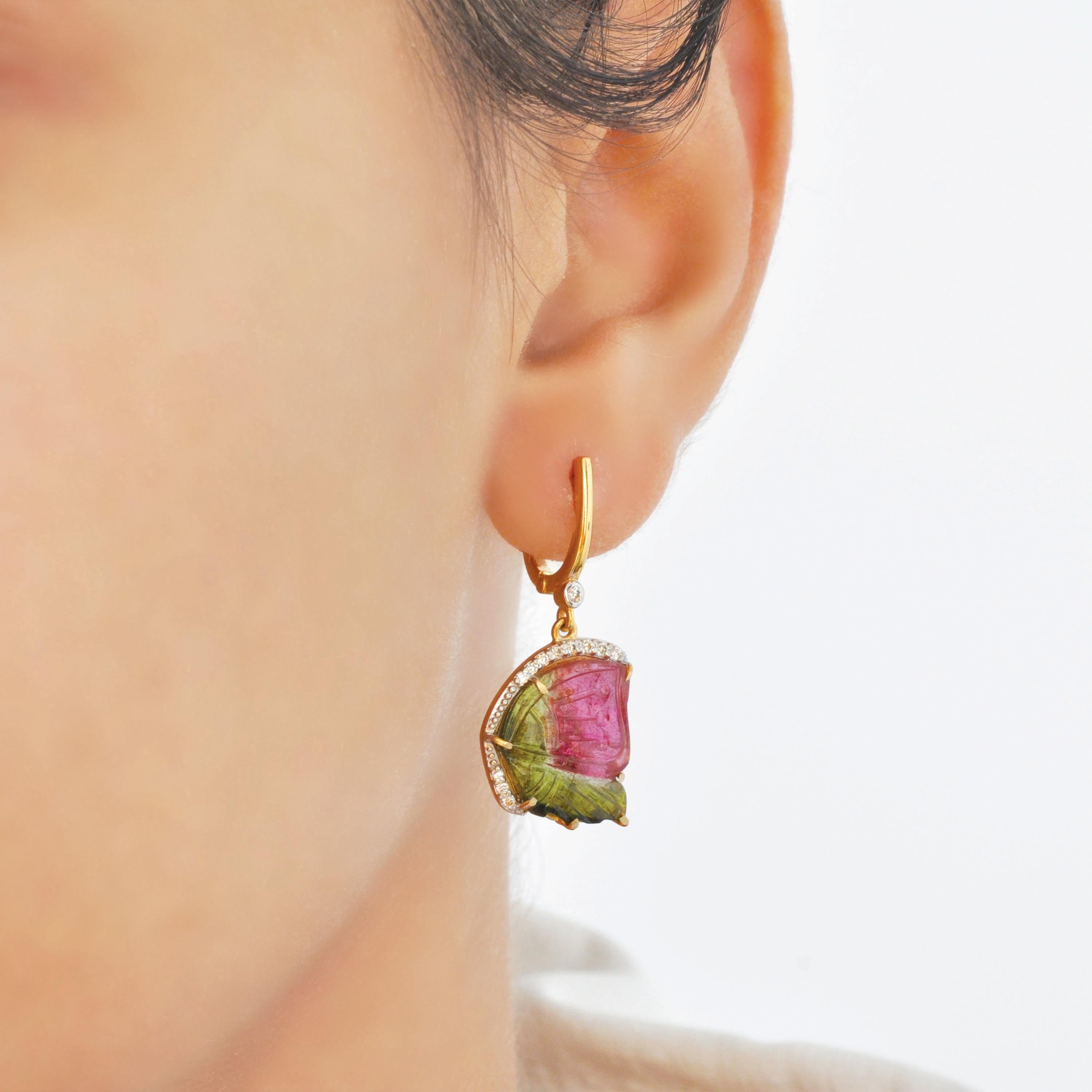 These stunning 14 Karat Yellow Gold dangle earrings are a celebration of elegance, artistry, and nature’s vibrant beauty. At the heart of these exquisite earrings are hand-carved watermelon tourmaline gemstones weighing 10.75 carats, masterfully