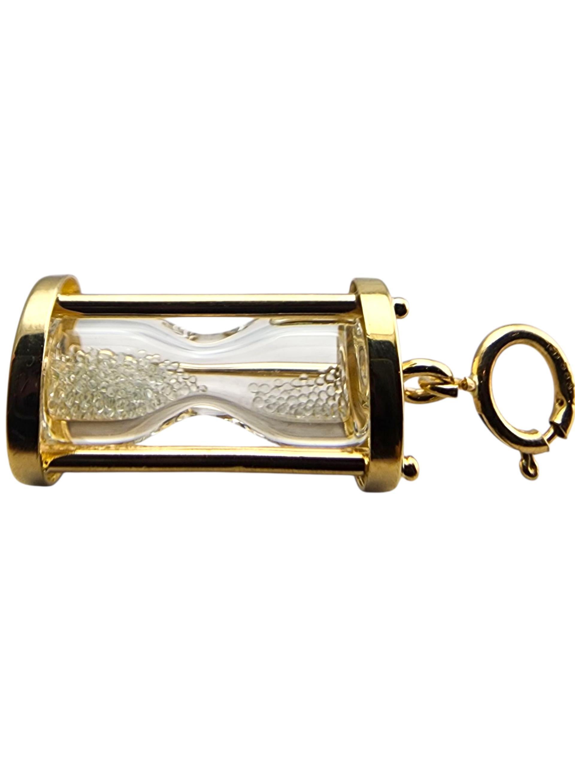 Charm a forma di clessidra in oro giallo 14 carati.

Questo charme a clessidra in oro giallo 14 carati presenta un disegno finemente dettagliato che simboleggia il tempo, la pazienza e l'equilibrio. La sua finitura lucida aggiunge una splendida