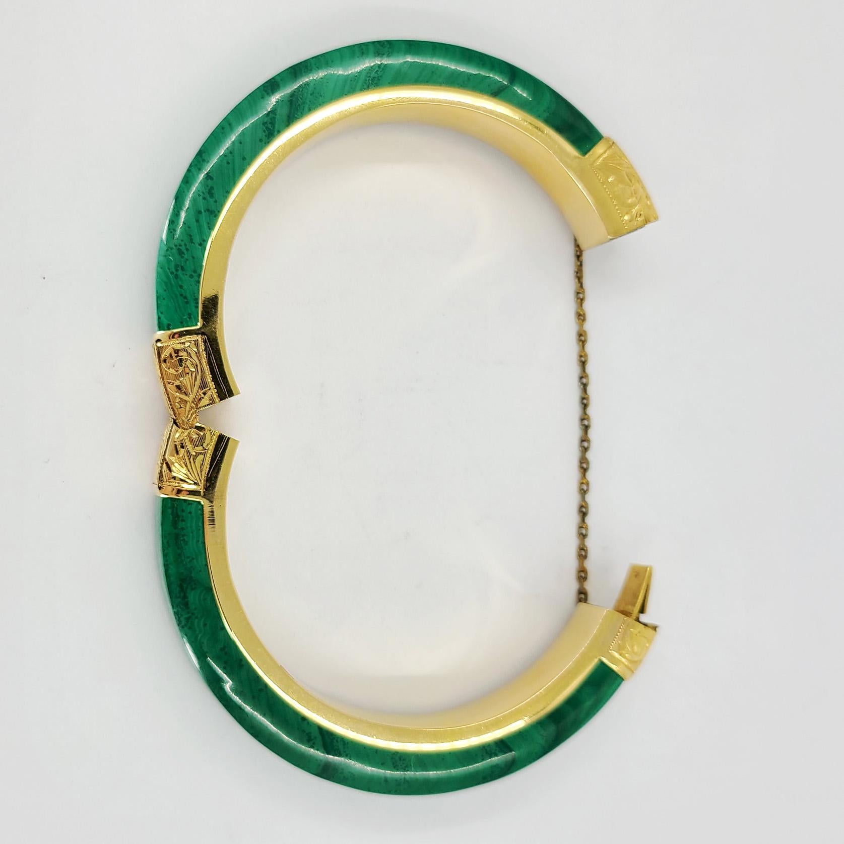 14 Karat Yellow Gold Imitation Malachite Bangle Bracelet. Hinged & Engraved Design With Safety Chain. Finished Weight Is 62.8 Grams.