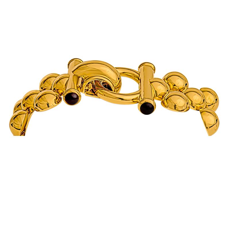Elevate your style with this elegant bracelet, meticulously crafted from polished 14 karat yellow gold that weighs 79 grams. It features garnet accents for an extra touch. Its sophisticated design makes it a perfect accessory for any occasion,