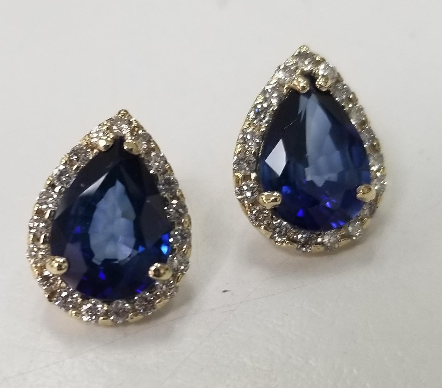 14 karat yellow gold Synthetic sapphire and diamond pear shape halos, containing 2 pear shape Synthetic sapphires weighing 6.41cts. surrounded by 38 round full cut diamonds weighing .65pts.
