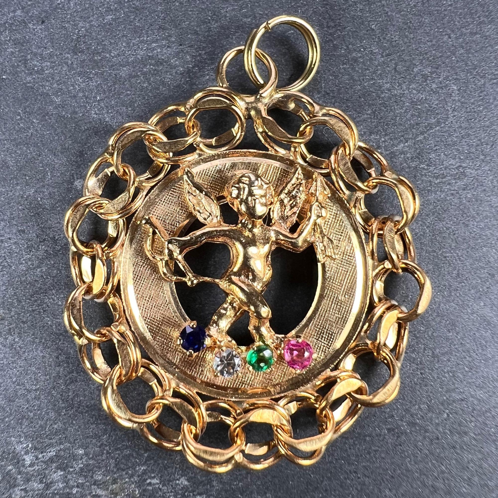 A large 14 karat (14K) yellow gold charm pendant designed as a cupid with bow and arrow standing over red, blue, green and white paste in a circular frame. Unmarked but tested for 14 karat gold.

Dimensions: 3.3 x 2.9 x 0.35 cm (not including jump