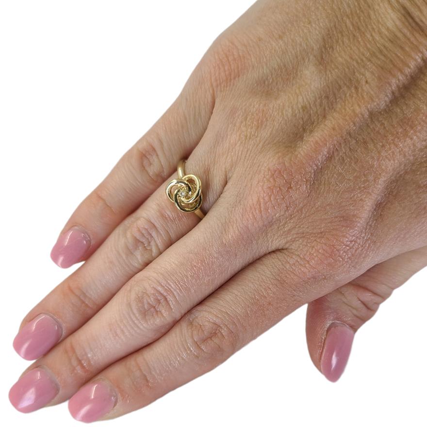 14 Karat Yellow Gold Love Knot Ring Featuring A Prong-Set 0.02 Carat Round Diamond. Finger Size 5.75; Purchase Includes One Free Sizing. Finished Weight Is 3.0 Grams.