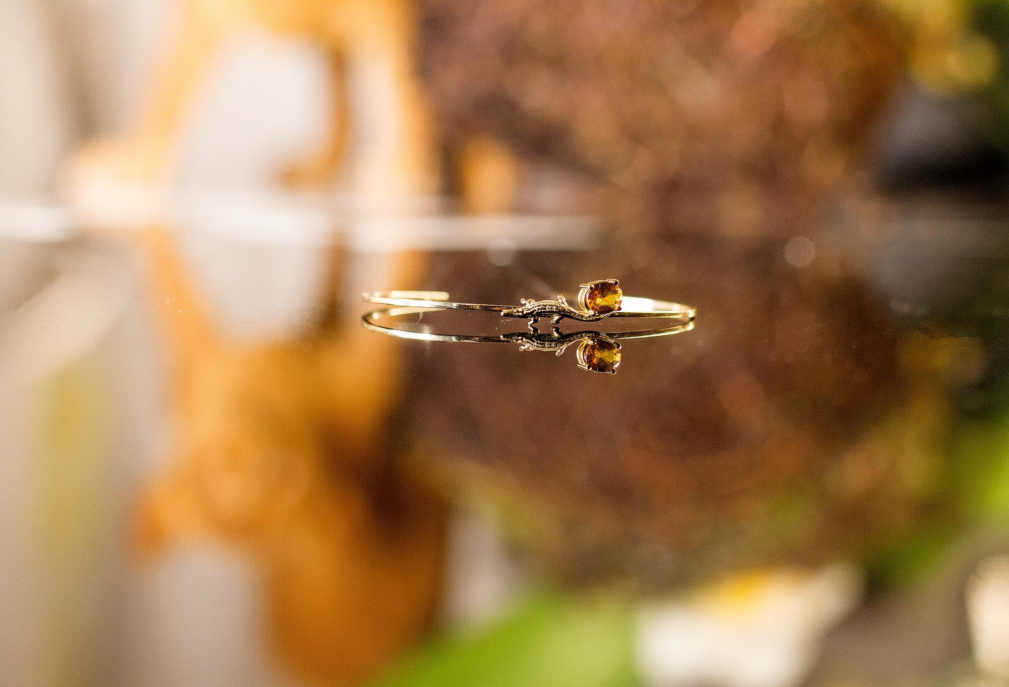 This Mesopotamian contemporary bangle bracelet is made of 14 karat yellow gold and is encrusted with a natural oval yellow sapphire.

This piece is available to order in white, rose, or yellow gold, with a variety of other gemstones including