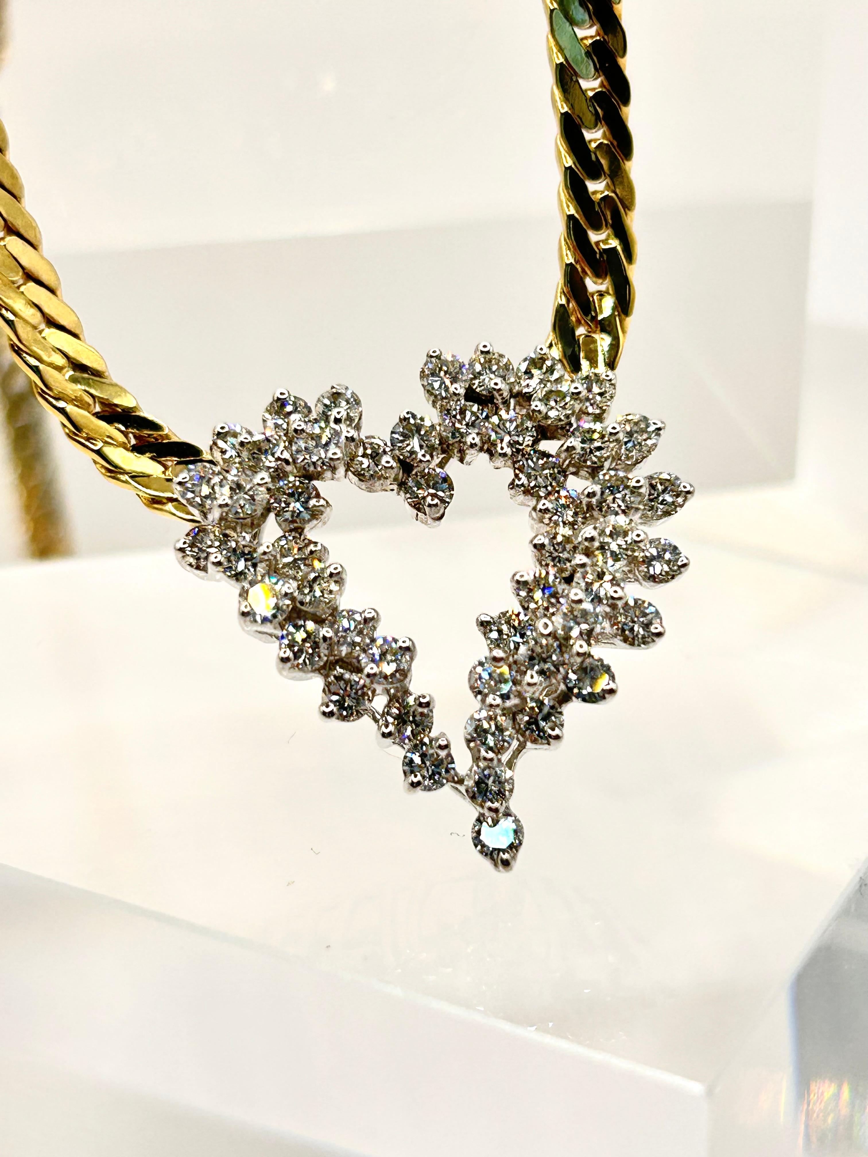 2.50 Carat Total Weight of Round Brilliant Cut Diamonds, set in Heart Design in 14 Karat White Gold attached to 14 Karat Yellow Gold Herringbone Chain.  Average Color of Diamonds is H-I and average Clarity is VS.