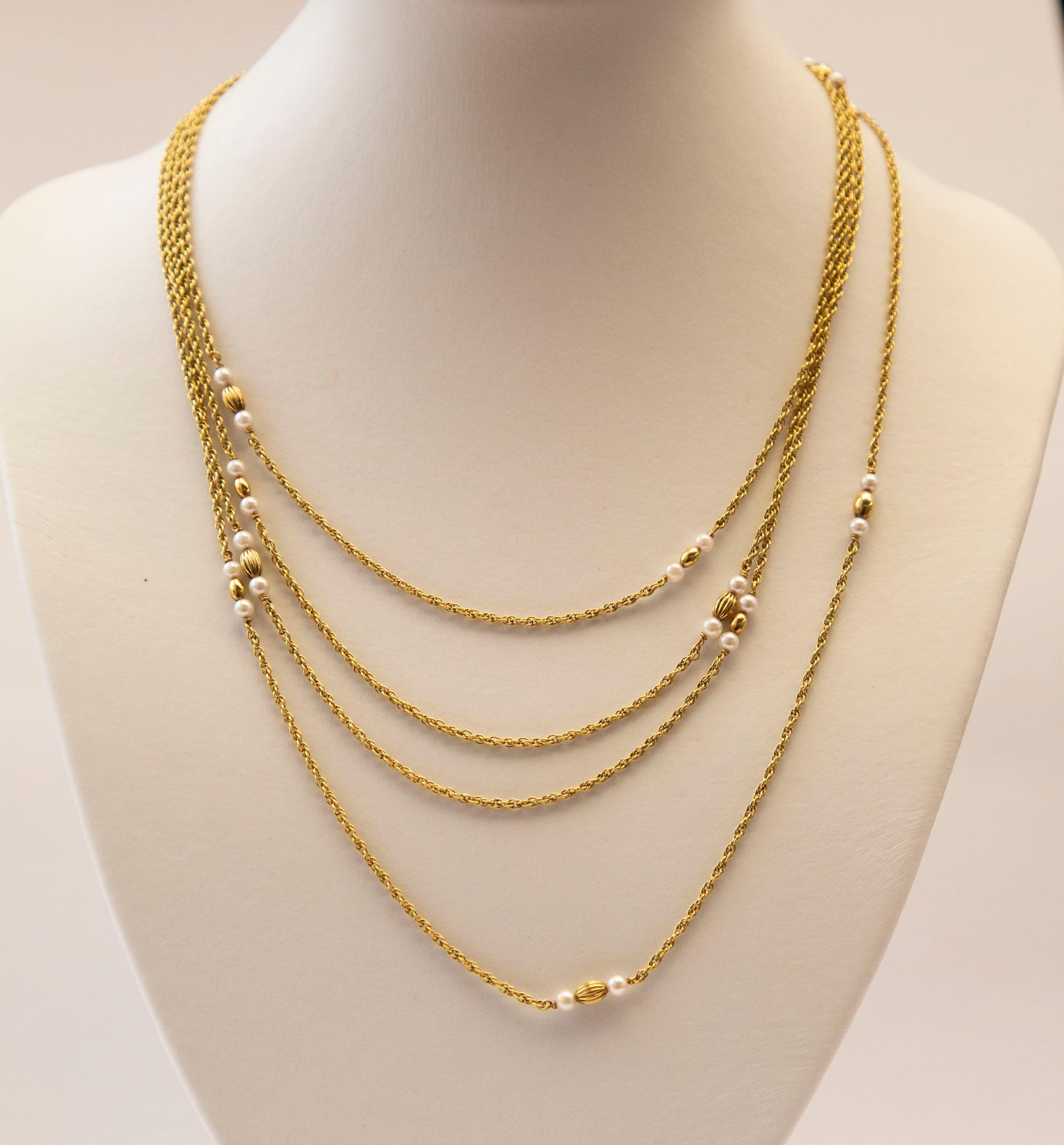 A 14 karat yellow gold rope link necklace with cream pearls, 14 karat yellow golden decorative beads, and a 14 karat yellow golden barrel lock. The necklace was manufactured by the German JKa Kohle Company of Pforzheim known for the production of